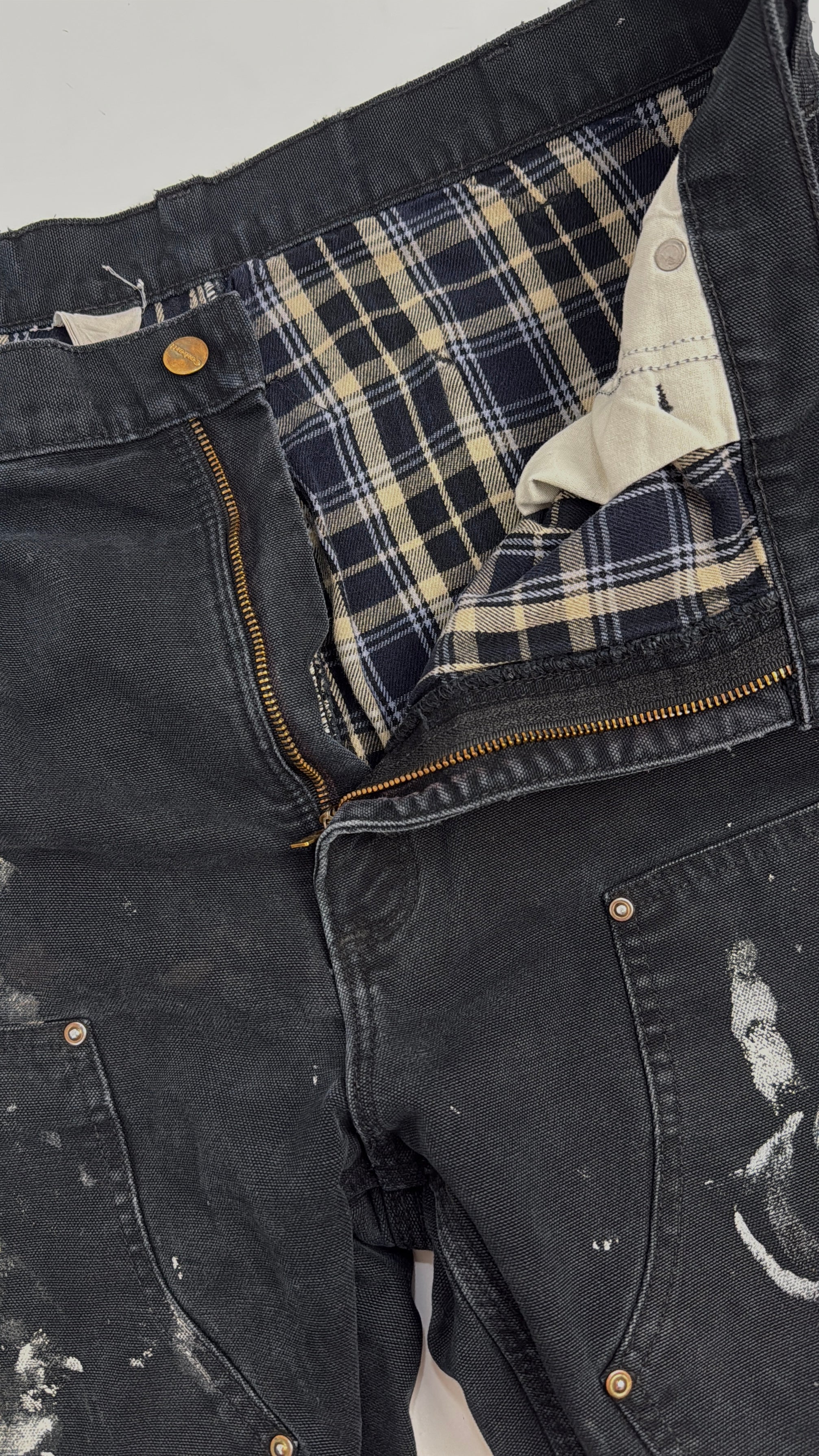 Carhartt Double Knee Flannel-Lined Vintage Nero - dettaglio apertura frontale con fodera interna in flanella tartan navy/crema, zip in ottone e rivetti ottone