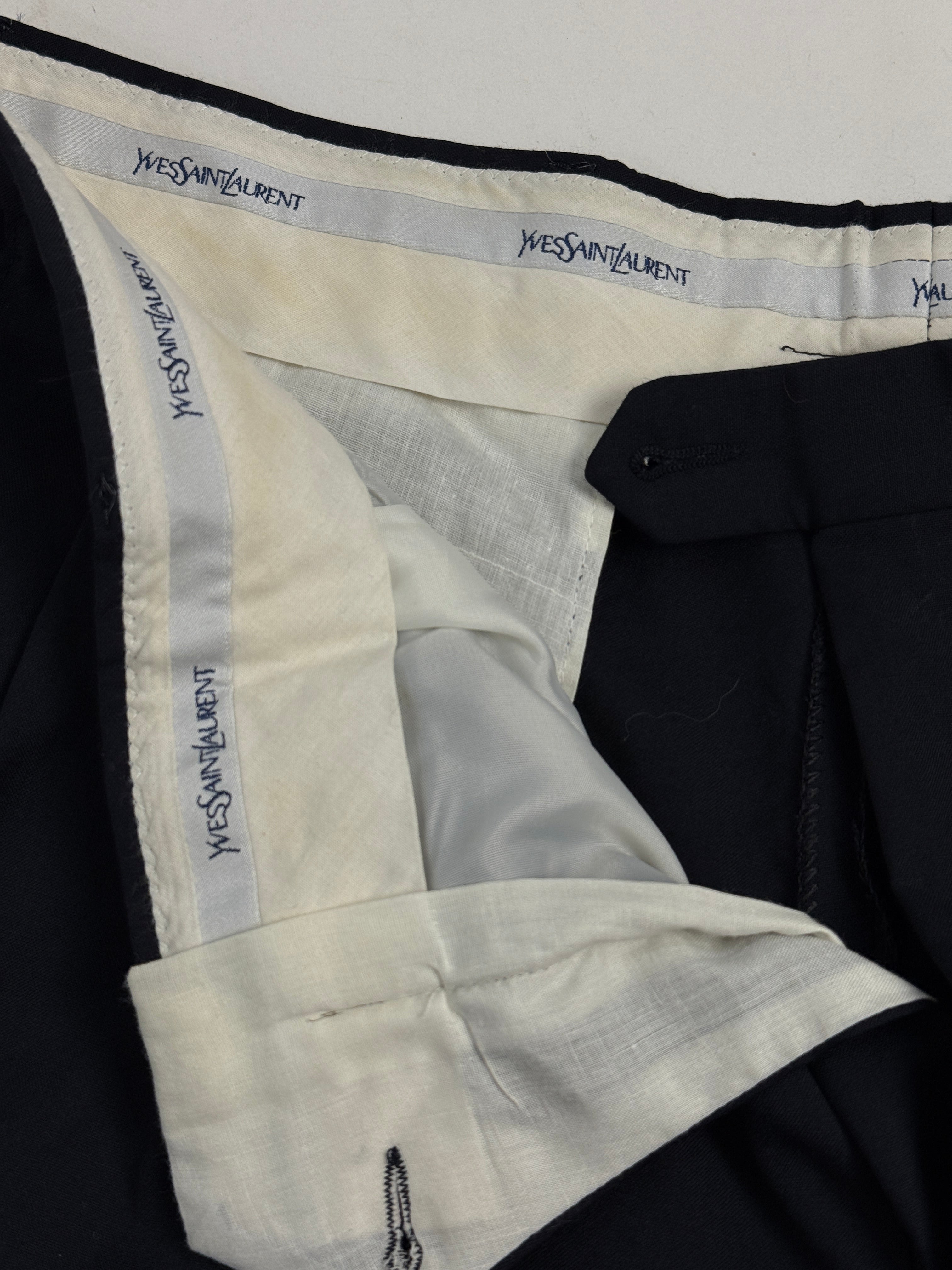 Dettaglio interno pantalone YSL - etichetta firma Yves Saint Laurent multipla e clip porta-bretelle