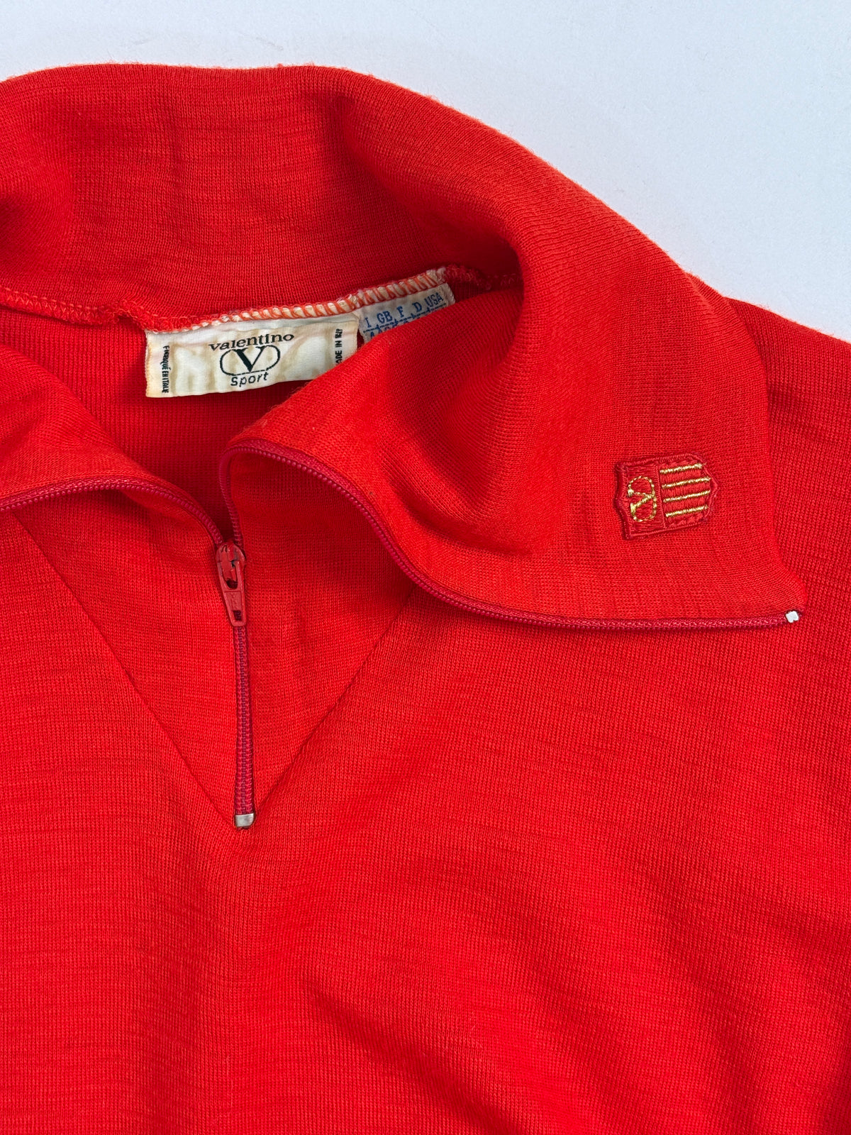 Dettaglio etichetta Valentino Sport Made in Italy e collo Spread zip pull rosso vintage