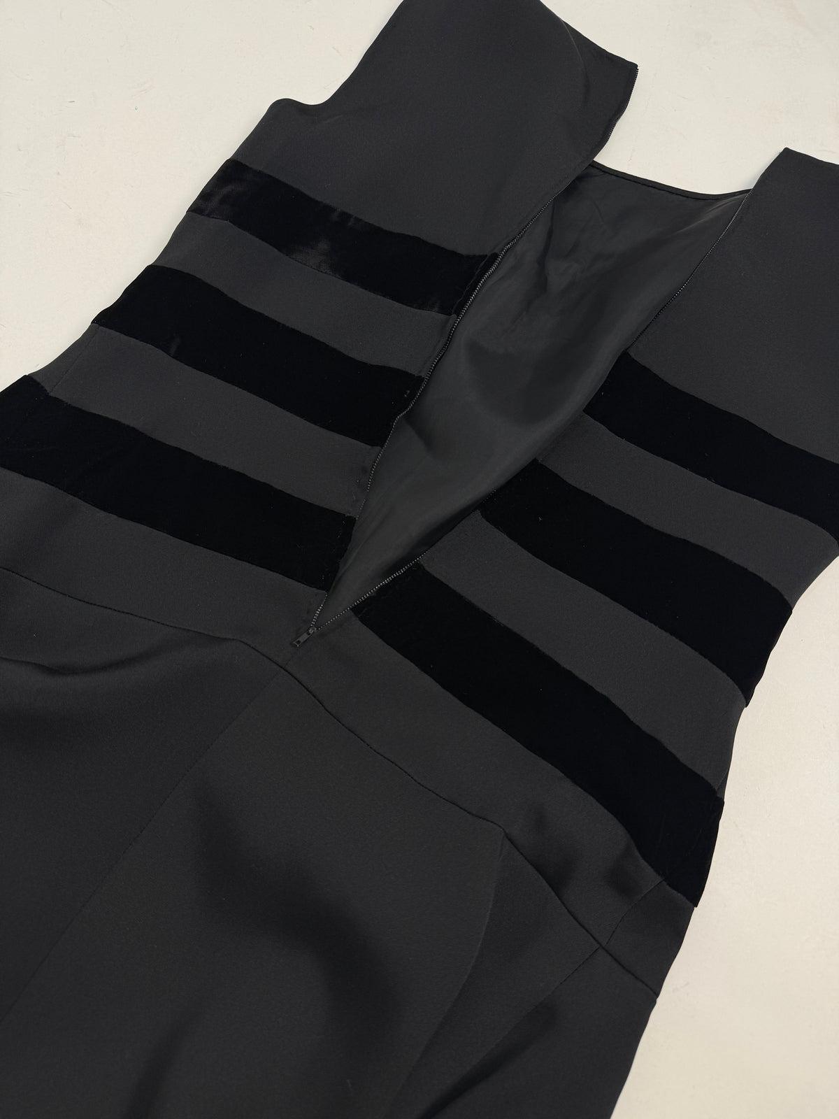 Dettaglio piano retro - zip laterale invisibile, bande velluto orizzontali retro, tessuto grigio antracite satinato, costruzione sartoriale