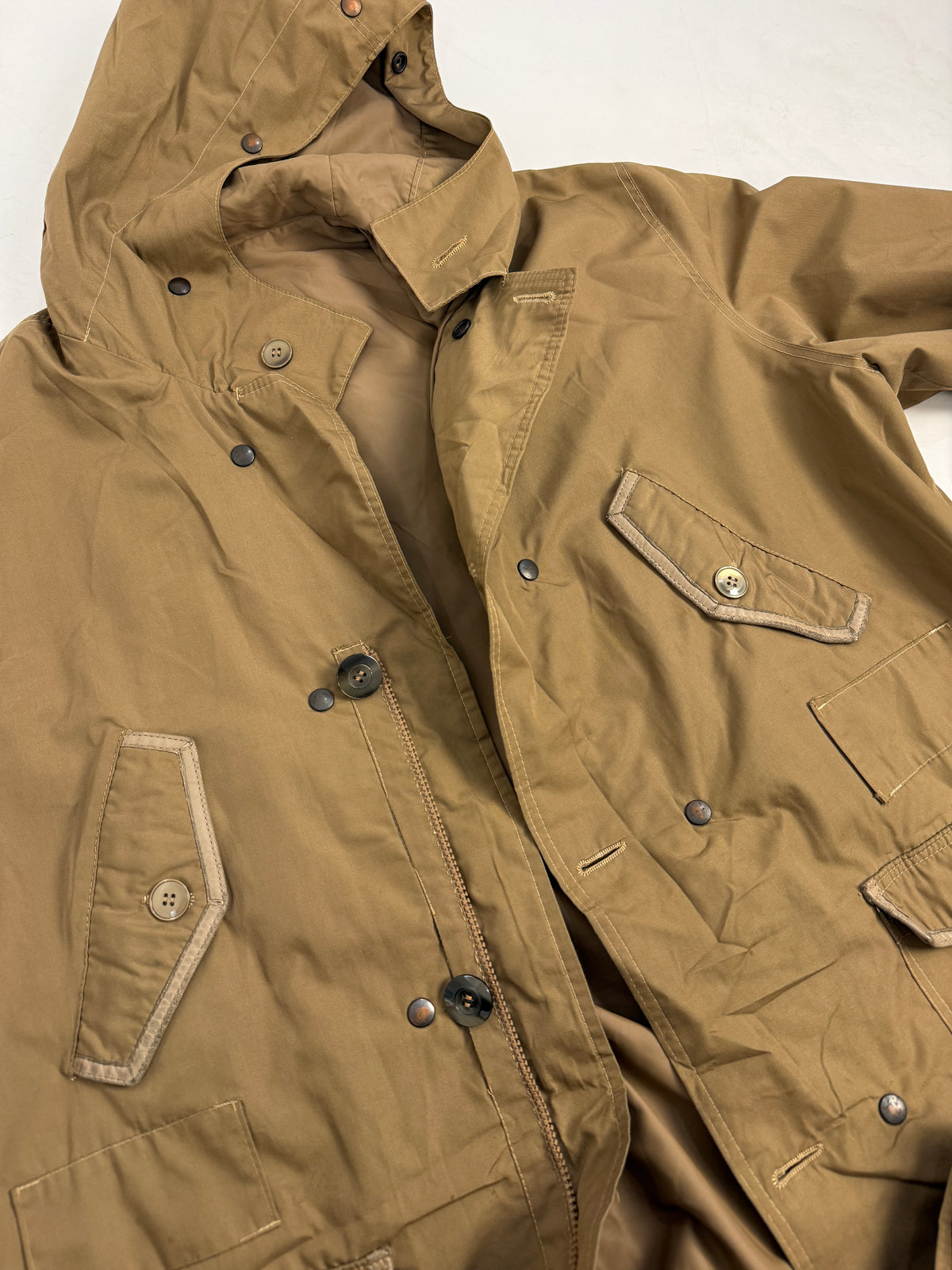 Dettaglio macro polsino e tasca cargo - bordura binding beige chiaro sul polsino, tasca cargo grande a soffietto con patta triangolare appuntita, bottone grigio, impunture filo crema