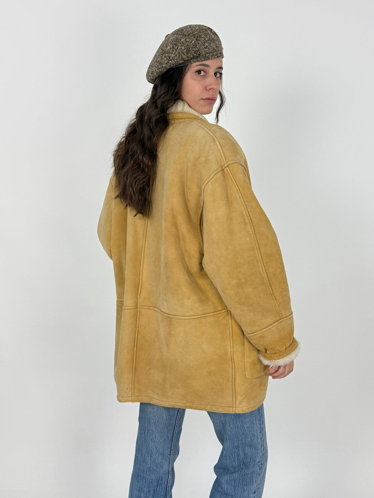 Dettaglio piano fronte - suede montone camel/sabbia con texture vellutata, due bottoni resina avorio su corpo, tasche toppa rettangolari con bottone avorio, cuciture decorative a vista