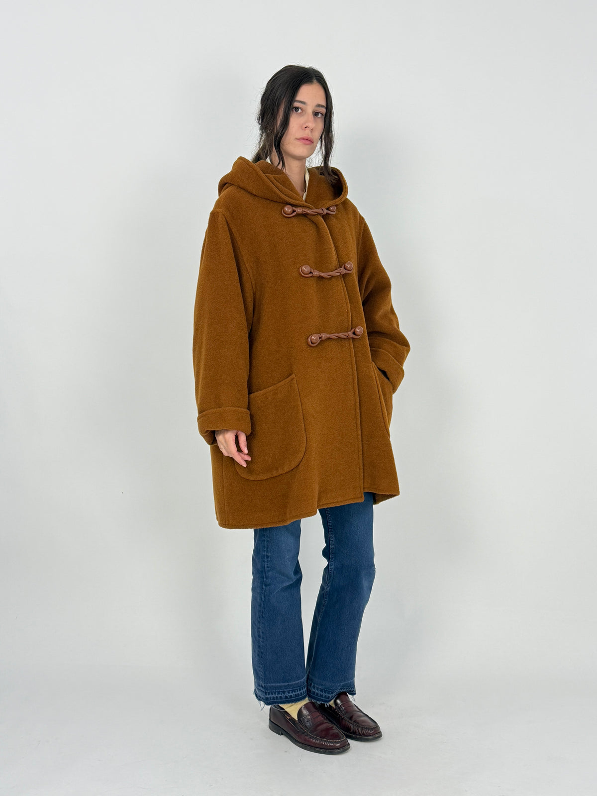 Etichetta MaxMara - scritta serif bianca made in Italy, tessuto alpaca lana cuoio tabacco, fodera jacquard micro-quadri ocra ambra in primo piano