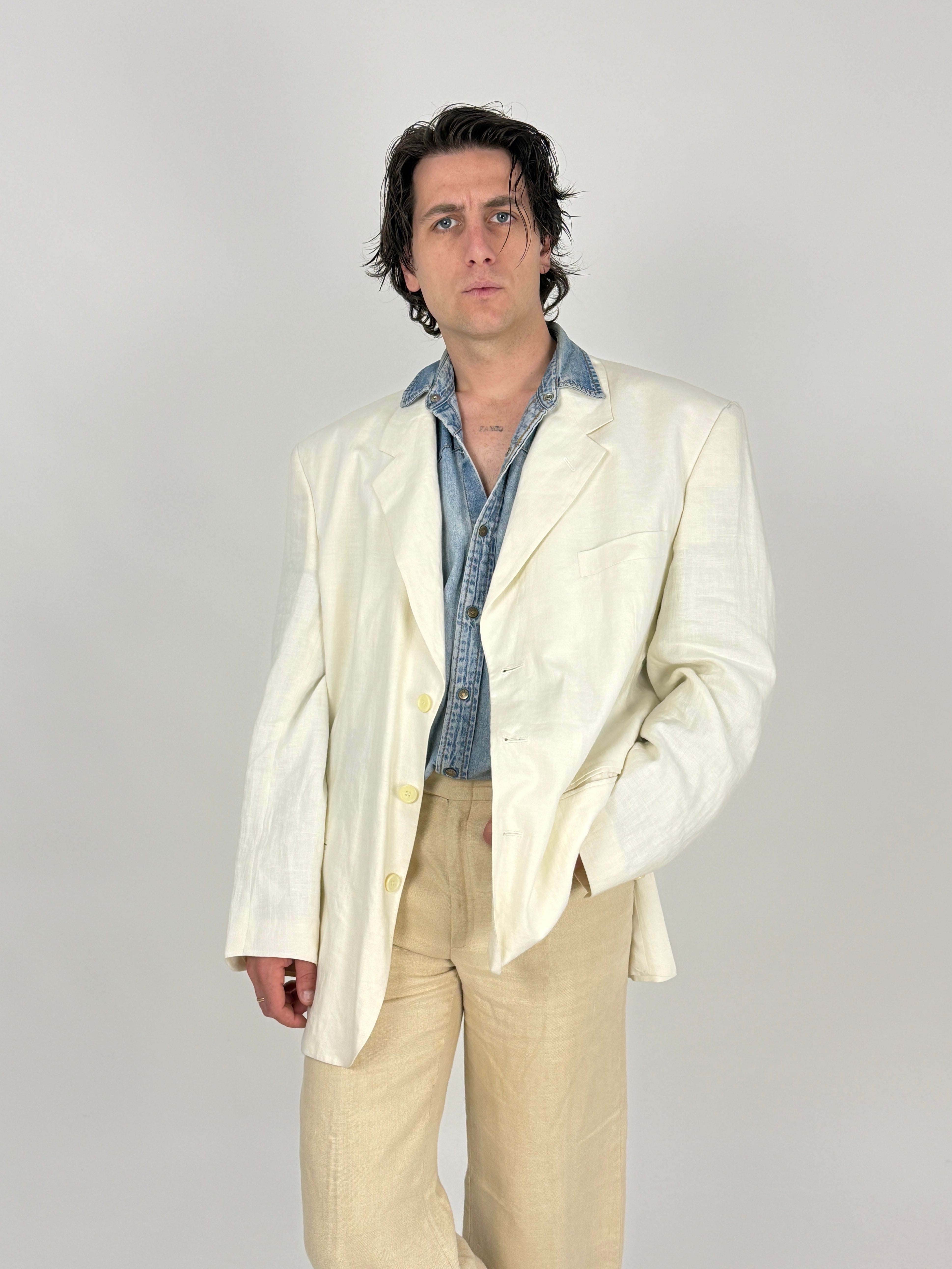 giacca in puro lino bianco avorio da uomo indossata con camicia in jeans e pantalone beige in lino