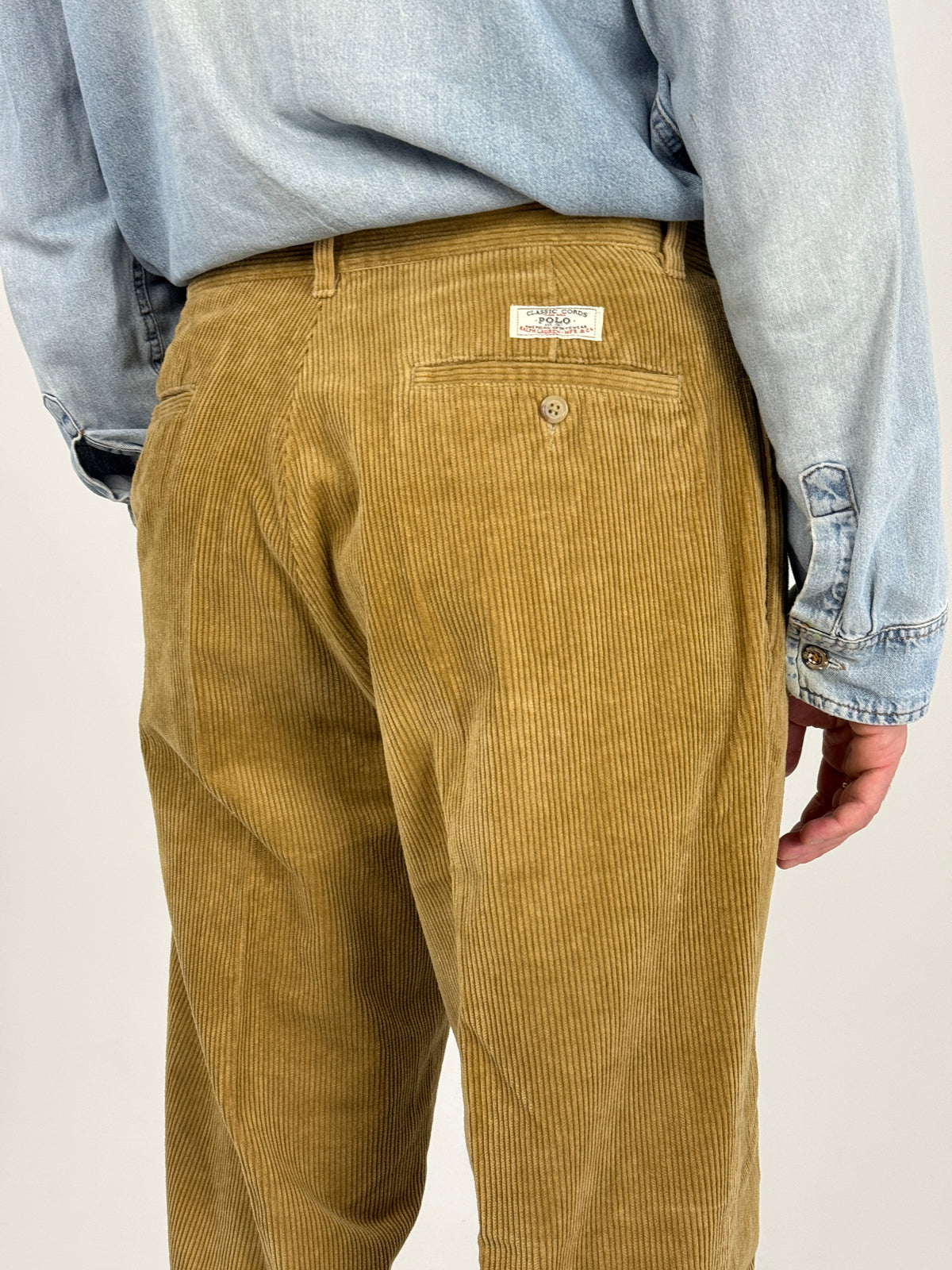 Dettaglio delle tasche posteriori dei pantaloni in velluto