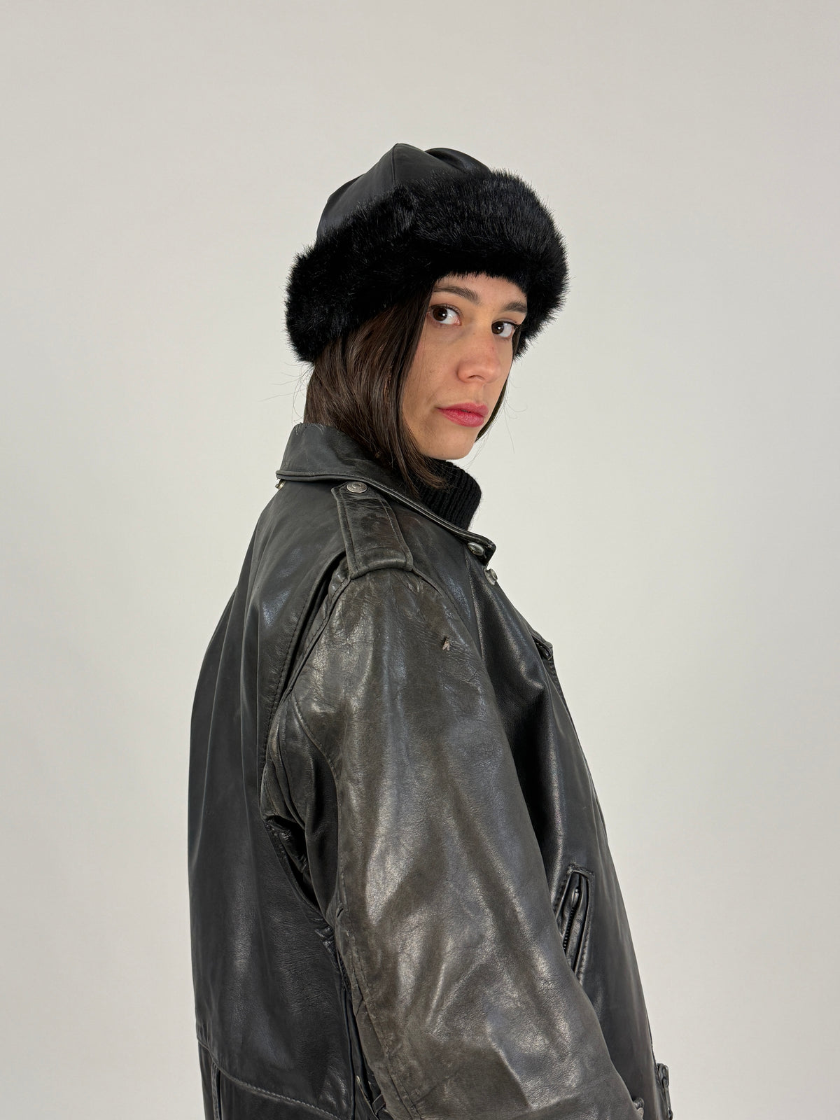 Cappello nero con bordo in ecopelliccia indossato di tre quarti
