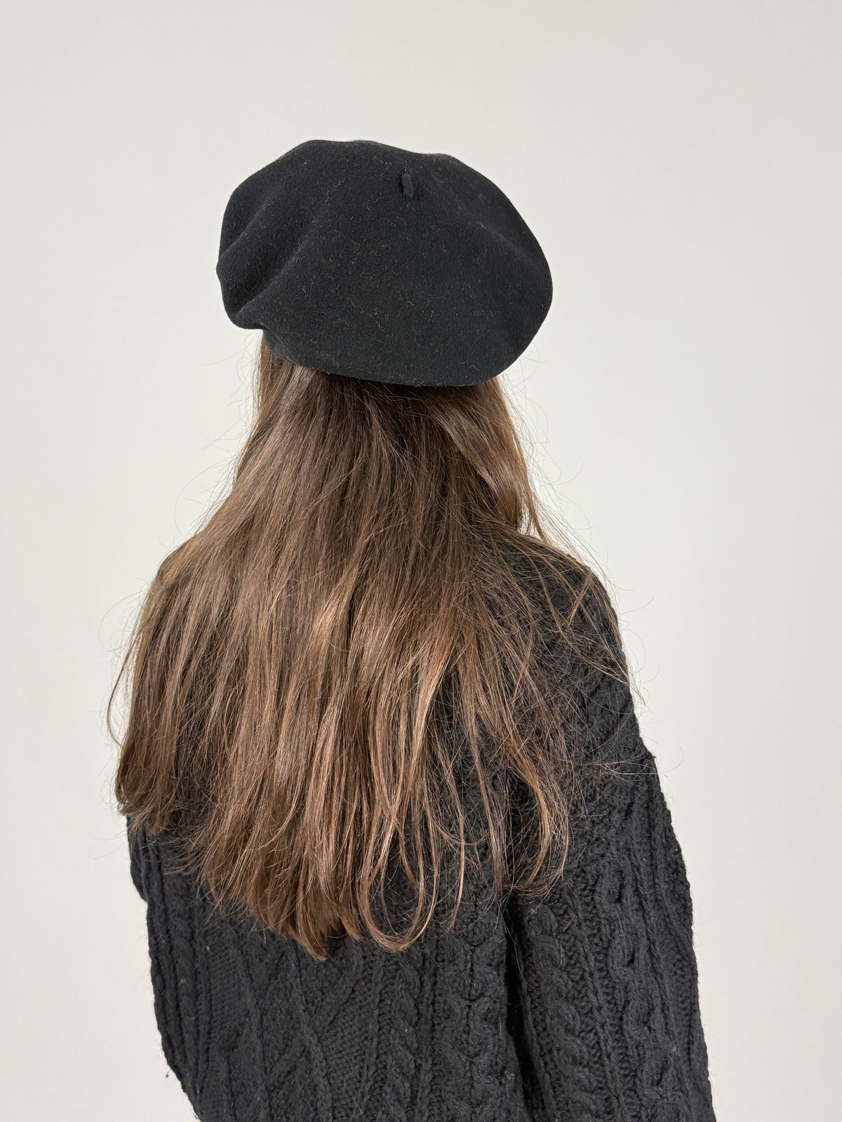 Vista posteriore del basco nero Kangol con picciolo centrale