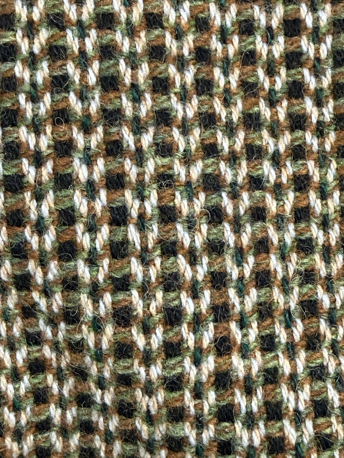 Primo piano del tessuto bouclé verde marrone e panna
