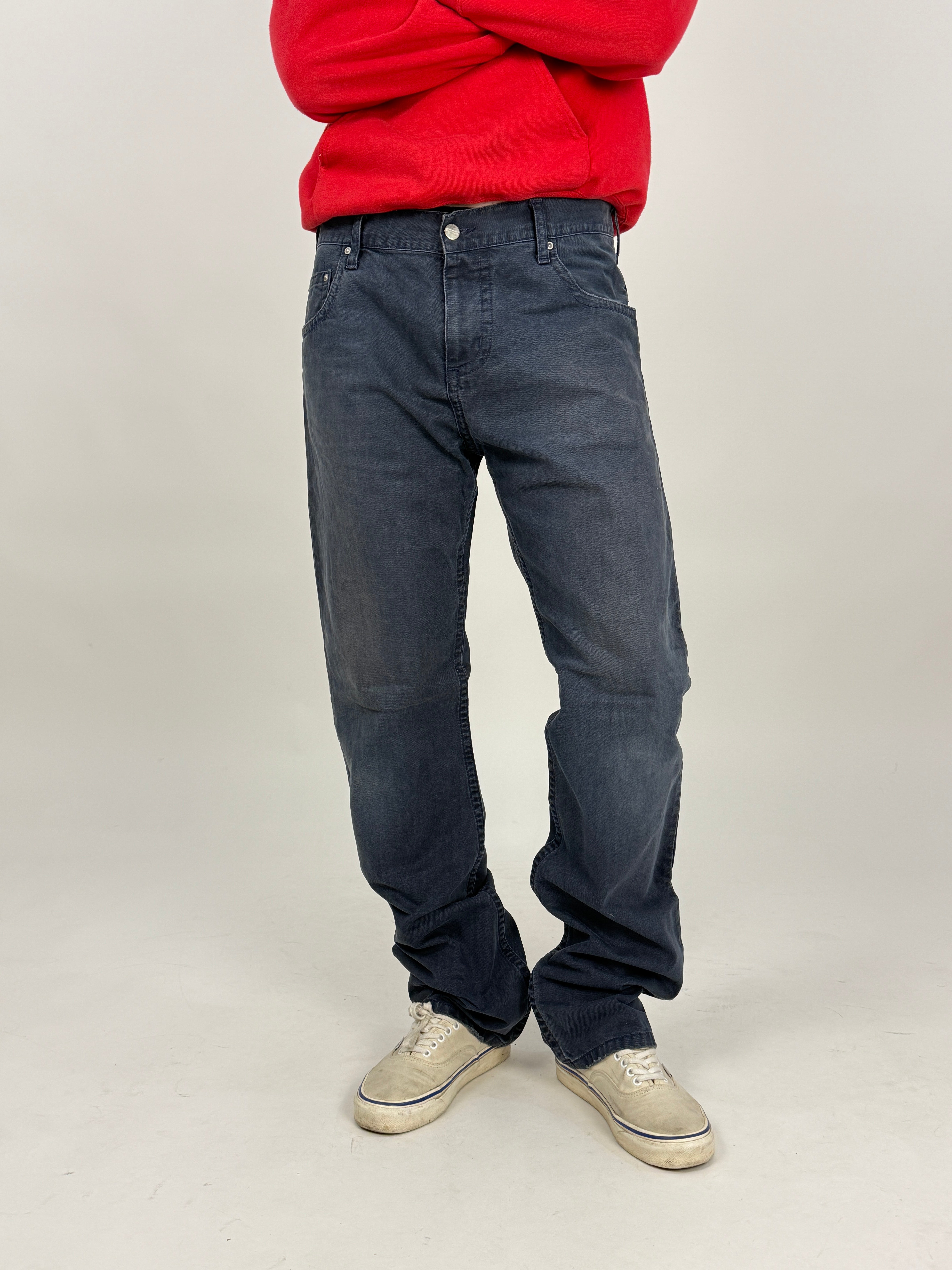 jeans carhartt wip blu da uomo indossato con felpa rossa e vans bianche