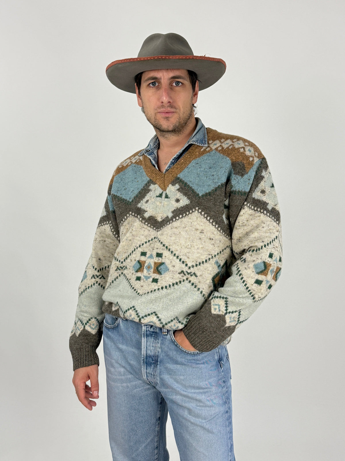 Maglione vintage anni 80 scollo V - fronte indossato con cappello western, jacquard macro geometrico avorio azzurro bronzo lurex, camicia denim