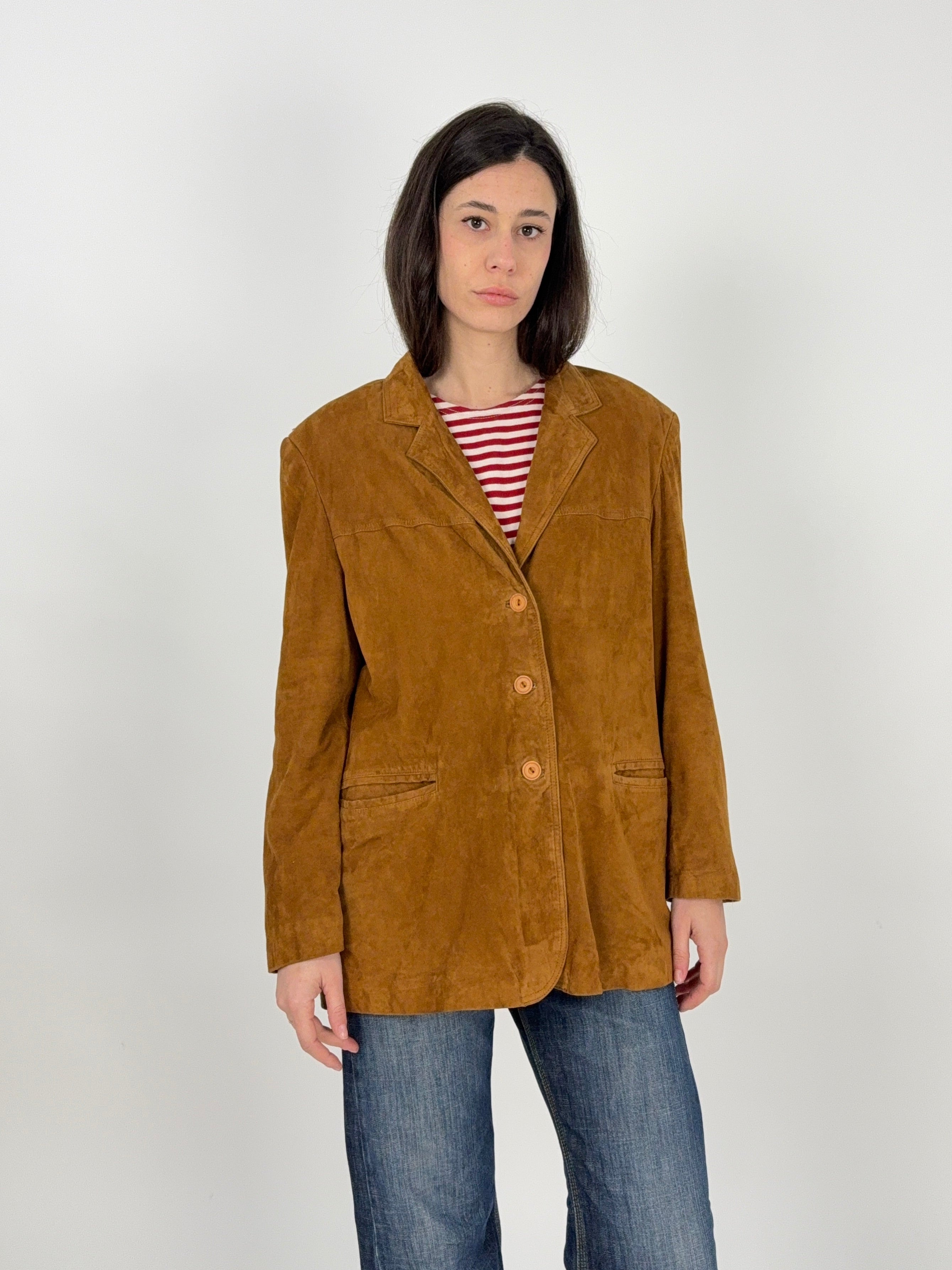 giacca in camoscio vintag indossata su donna con t-shirt a righe e jeans