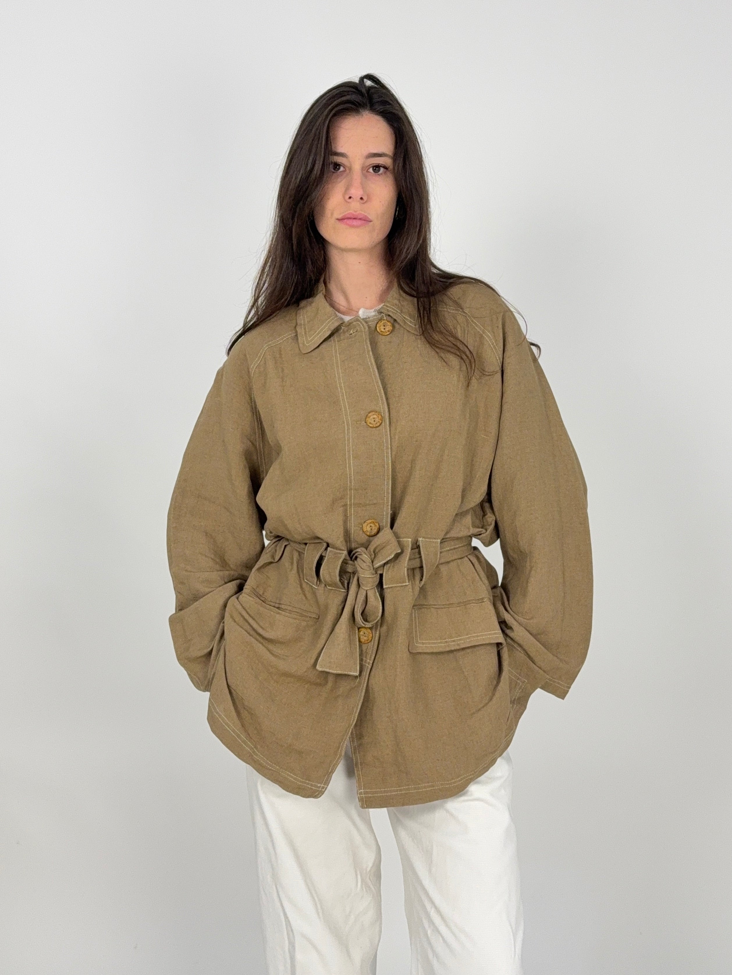 giacca sahariana da donna vintage colo tortora abbinata a dei pantaloni in cotone bianco