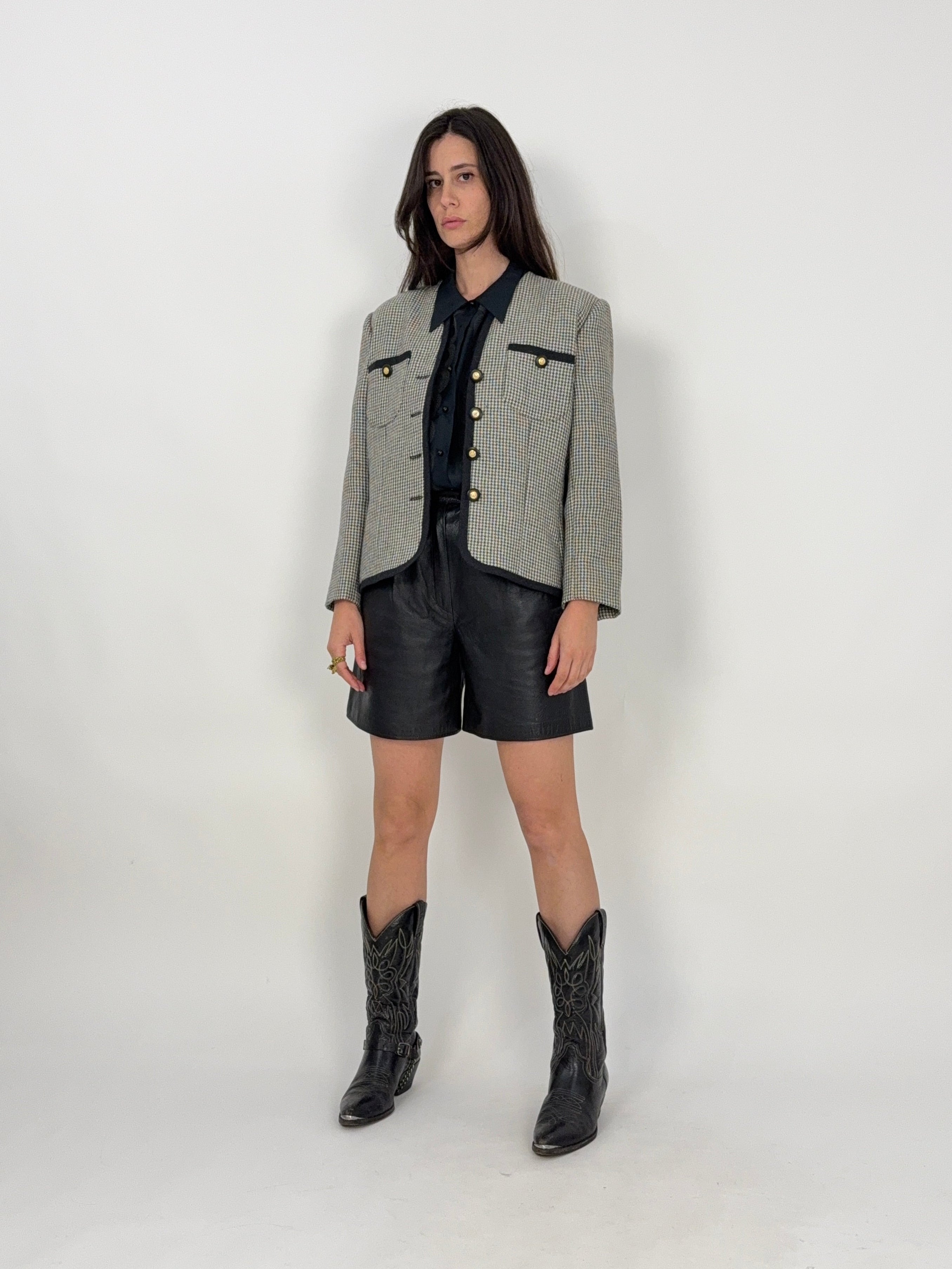 giacca luisa spagnoli vintage in lana pied de poule bianco e nero e bottoni oro indossata con camica nera e bermuda in vera pelle nera e texani