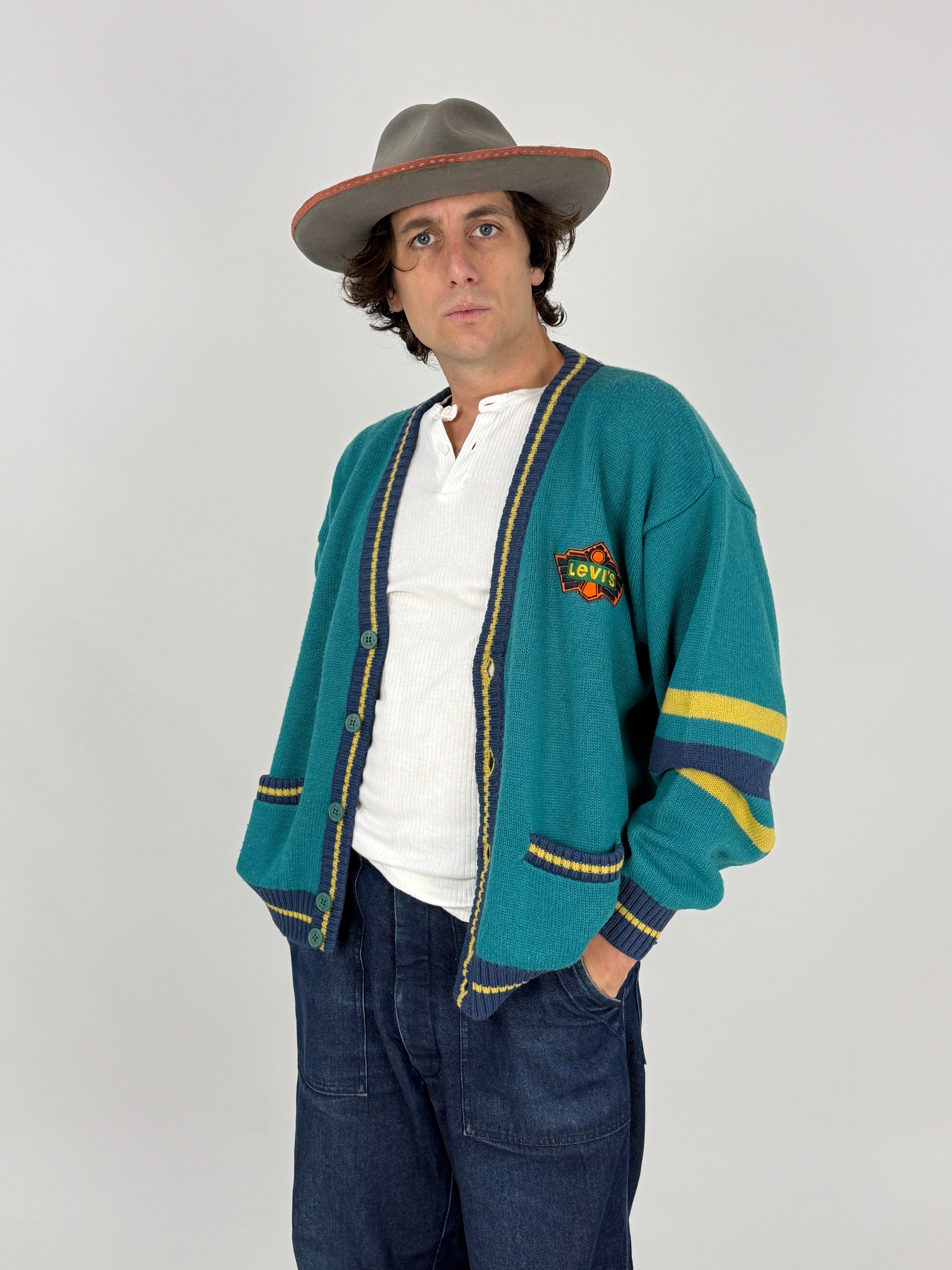 Cardigan Vintage Levi's Varsity Letterman Verde Teal - vista frontale chiuso indossato con jeans cargo blu e cappello grigio