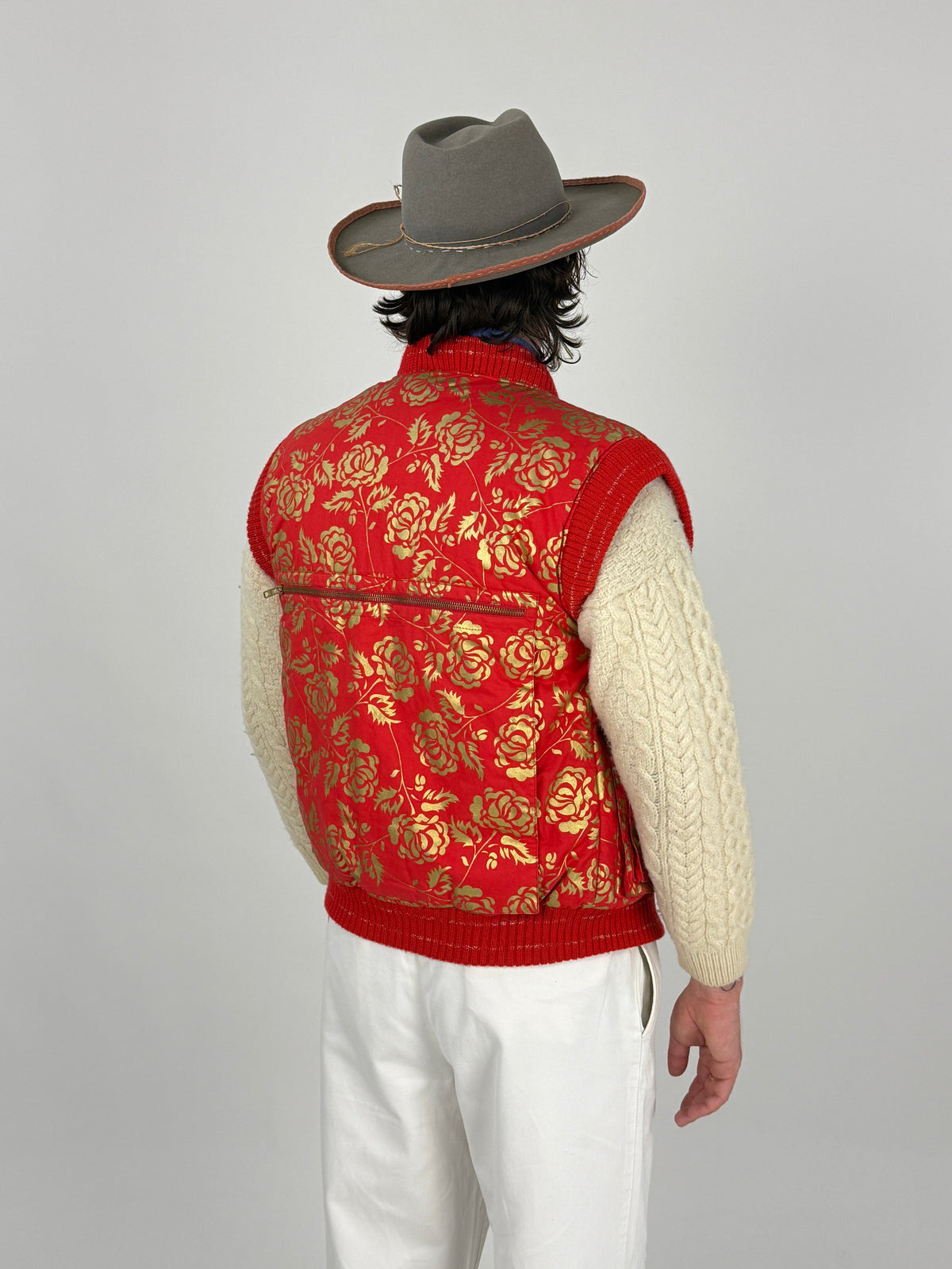 Gilet Vintage Emanuel Ungaro Sport d'Hiver Rosso Rose Dorate - vista frontale full body indossato su cable knit panna e pantaloni bianchi con cappello fedora grigio
