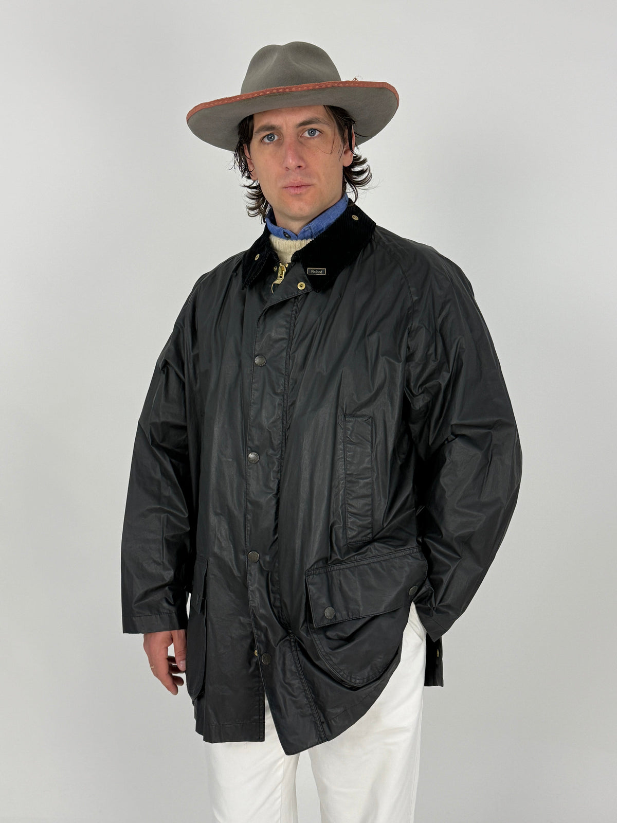 Giacca Cerata Vintage Polbot Nera - vista frontale full body indossata chiusa con cappello fedora grigio bordo rosso, camicia denim e Levi's 501 bianchi