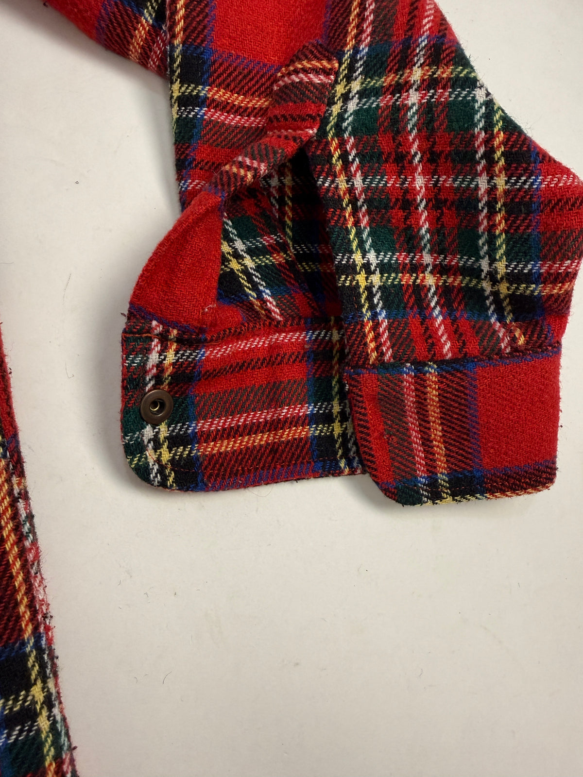 Dettaglio polsino smussato e bottone a pressione ottone brunito camicia flanella lana tartan anni 70