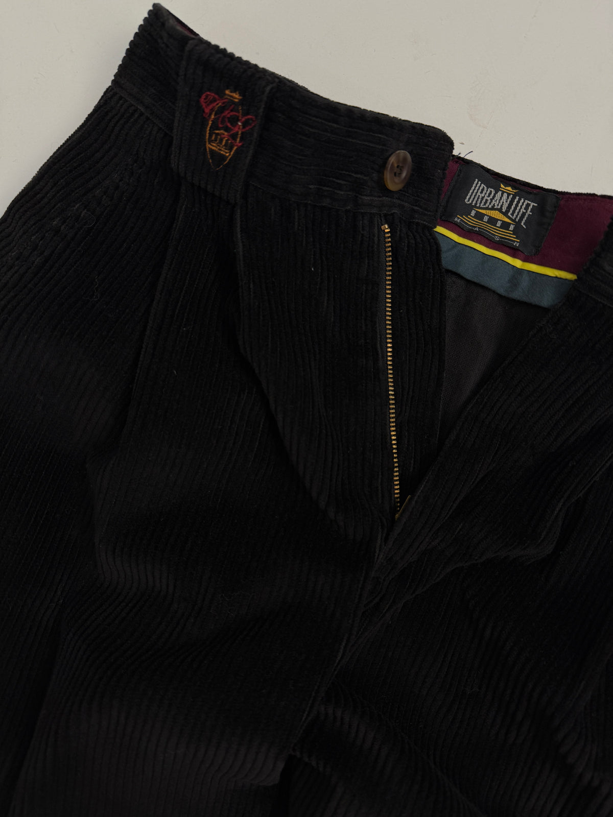 Dettaglio vita logo Mash ricamato scudo corona zip metallo etichetta Urban Life pantaloni velluto