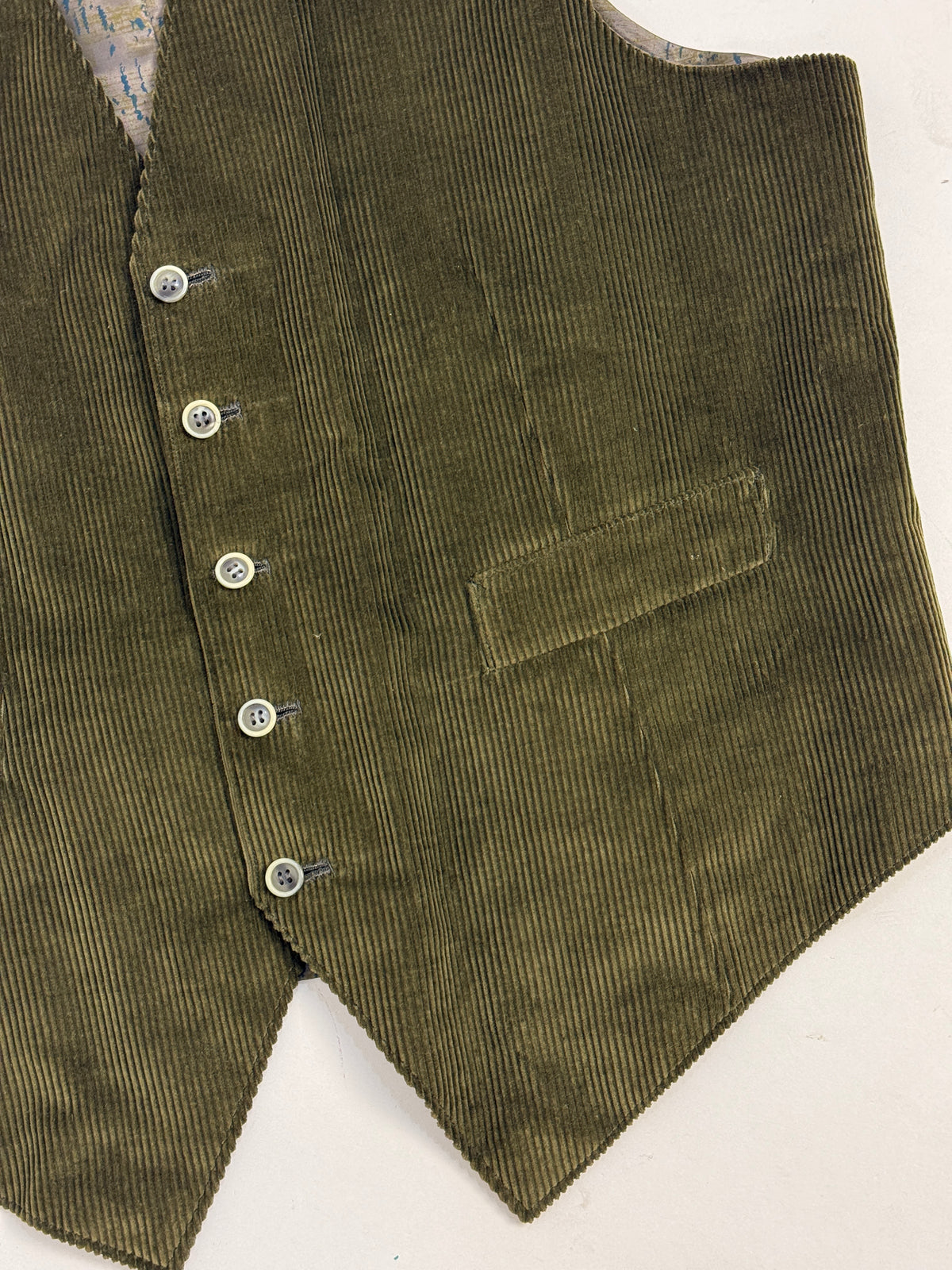 Dettaglio velluto e bottoni gilet vintage - costa larga verde oliva con bottoni madreperla bianchi e taschino petto sinistro