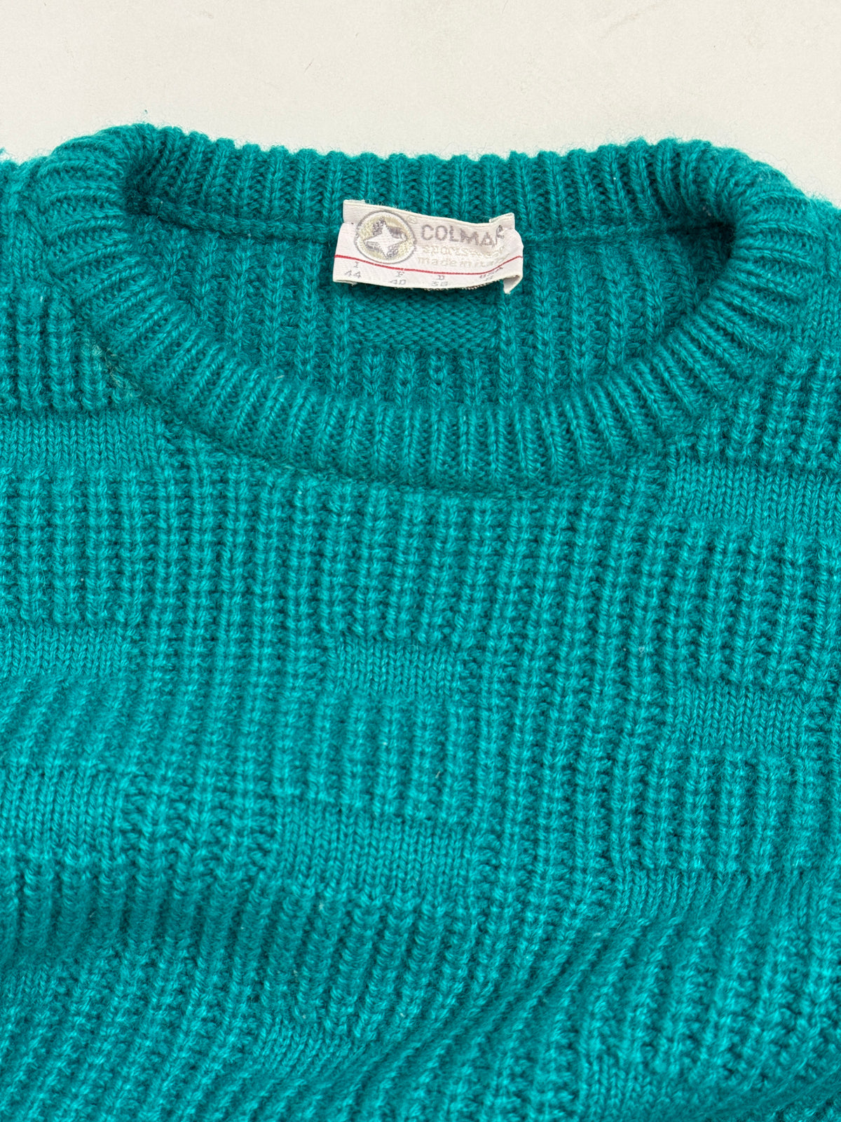 Dettaglio collo ed etichetta Colmar anni 80 - etichetta tessuta originale con logo stella, scala taglie I44/D46/F46/GB36, girocollo costina verde teal