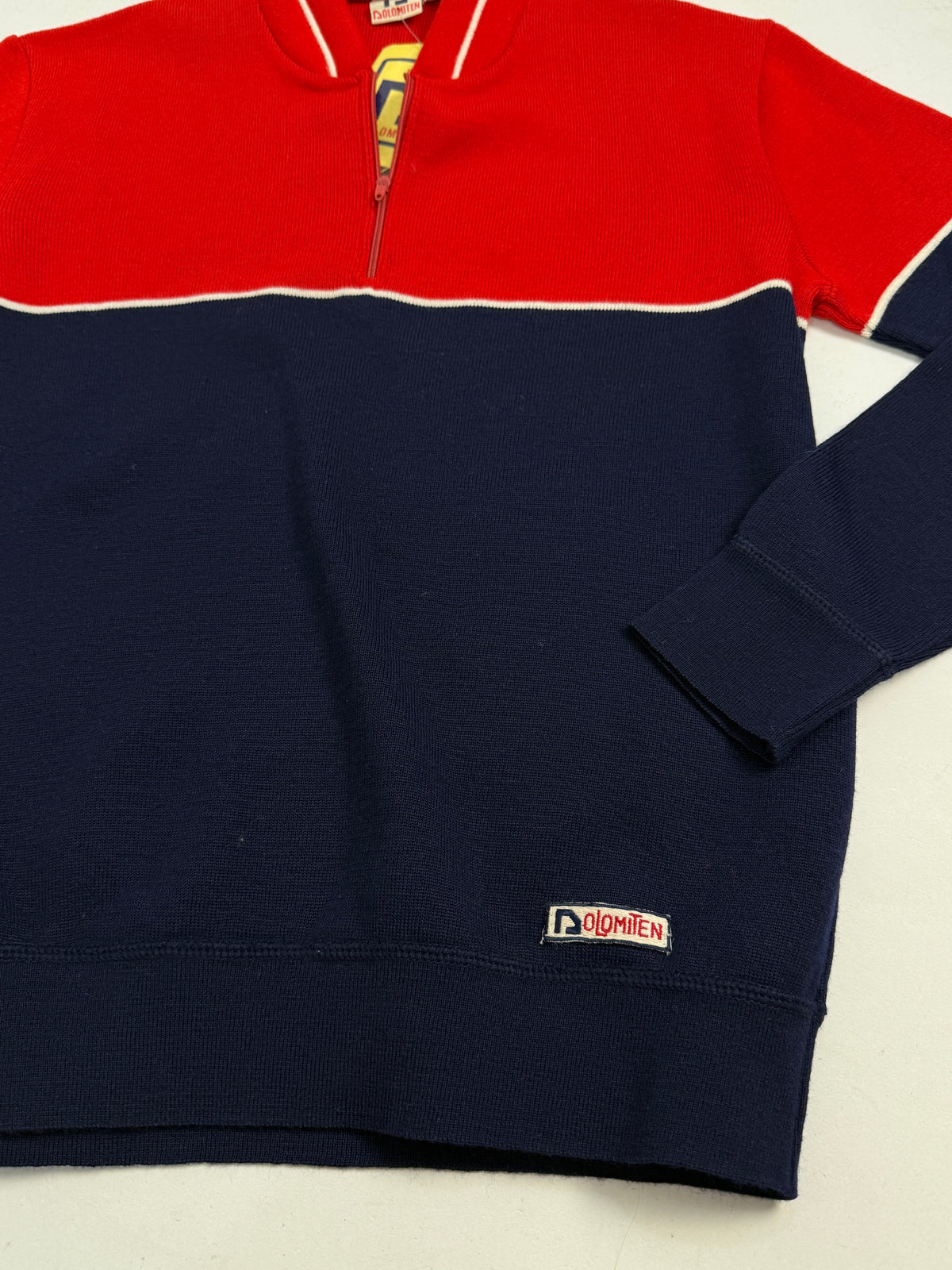 Maglione sci Dolomiten deadstock anni 70 - fronte indossato, bicolore rosso/blu notte con riga panna, half-zip, cappellino baseball rosso, jeans