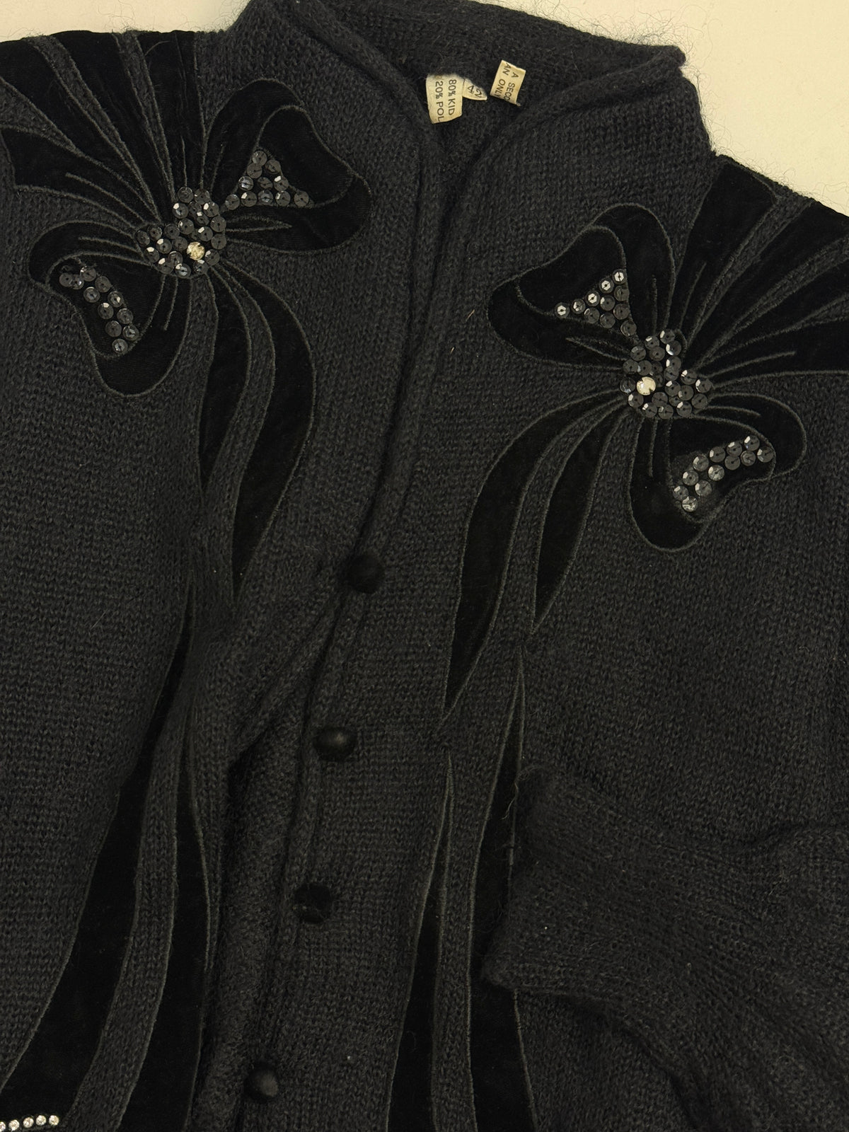 Cardigan kid mohair nero anni 70 - fronte indossato tre quarti, fiocchi velluto paillettes, nastri velluto, chiusura bottoni neri, silhouette crop