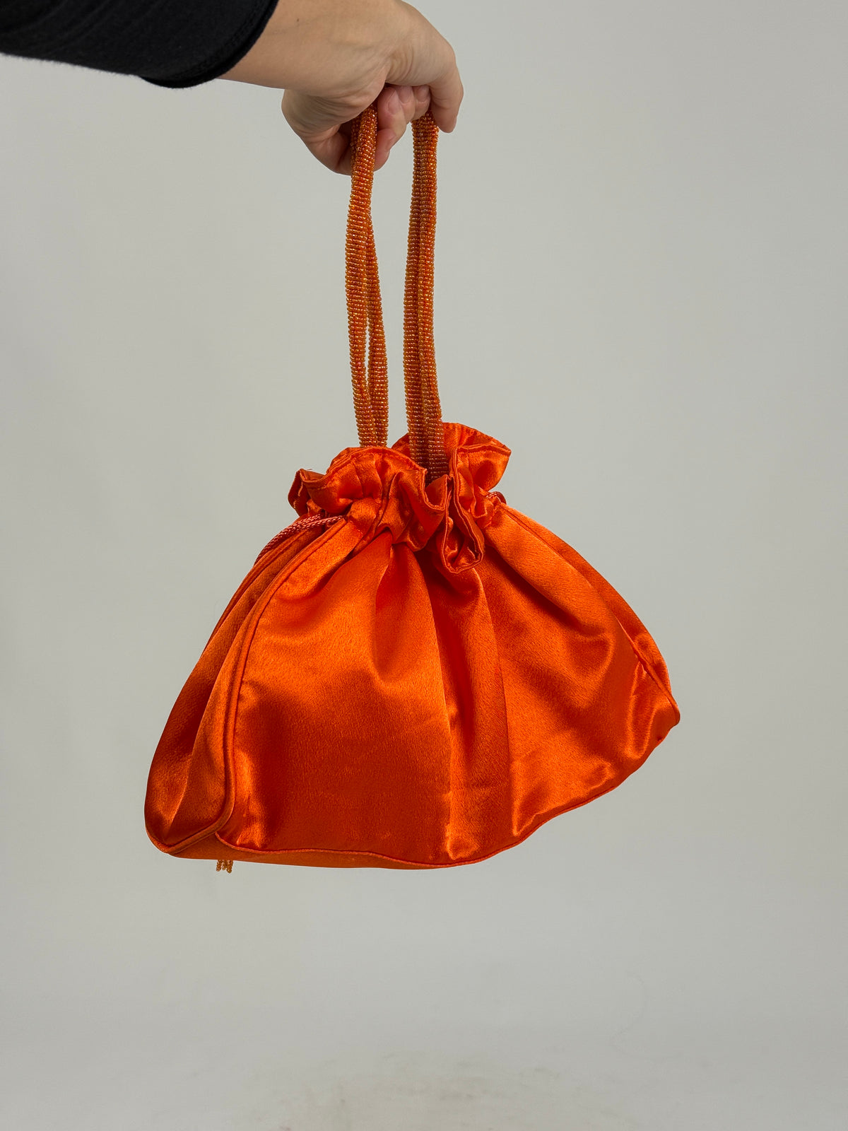 Borsa bucket bag - laterale fondo strutturato, bordura doppia in raso arancione che mantiene la forma, profondità cm 7, coulisse chiusa