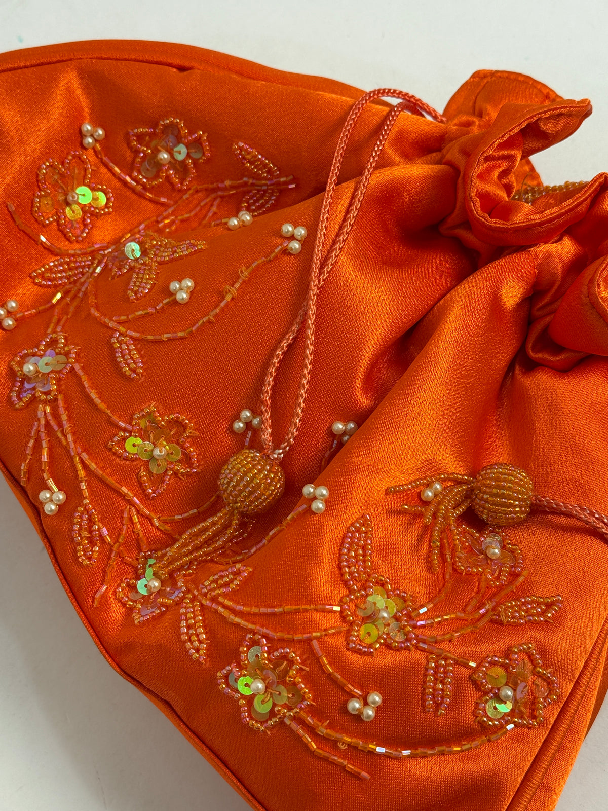 Dettaglio macro ricamo fronte - motivo floreale a tralcio con perline bianche avorio, paillettes oro-arancio iridescenti, bugle beads tubetti, uccellini e fiori ricamati a mano