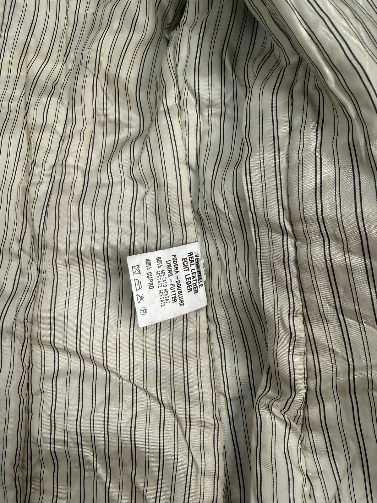 Dettaglio orlo inferiore cappotto - striscia decorativa pelo lungo nero non rasato che bordea l'orlo del cappotto, lapin rasato corpo, cuciture orizzontali a fasce, fodera righe avorio