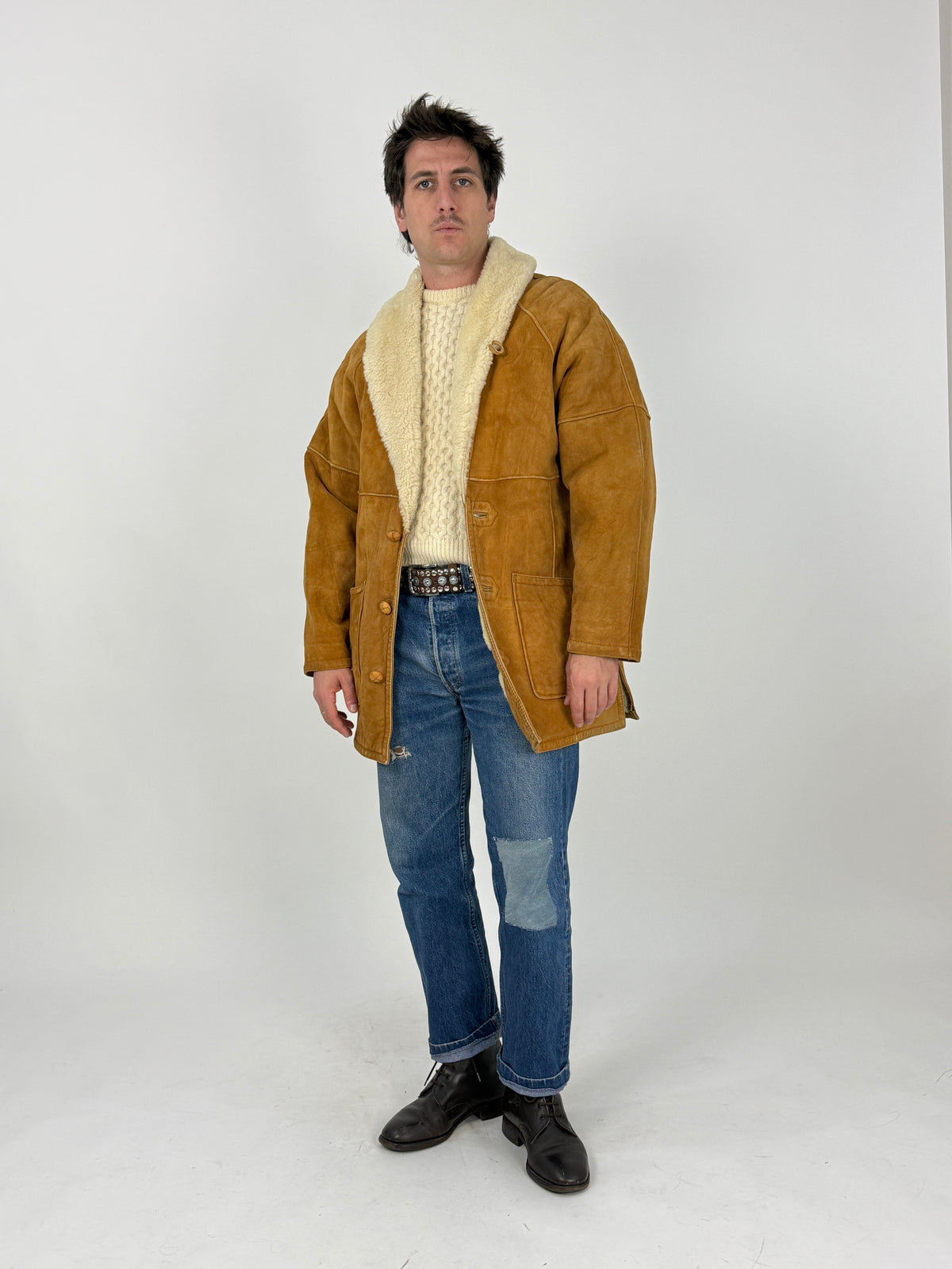 Dettaglio etichetta interna - etichetta Swearling calligrafico dorato su fondo nero, shearling riccio bouclé avorio denso e vaporoso, bordo suede butterscotch rifinito cucitura a vista