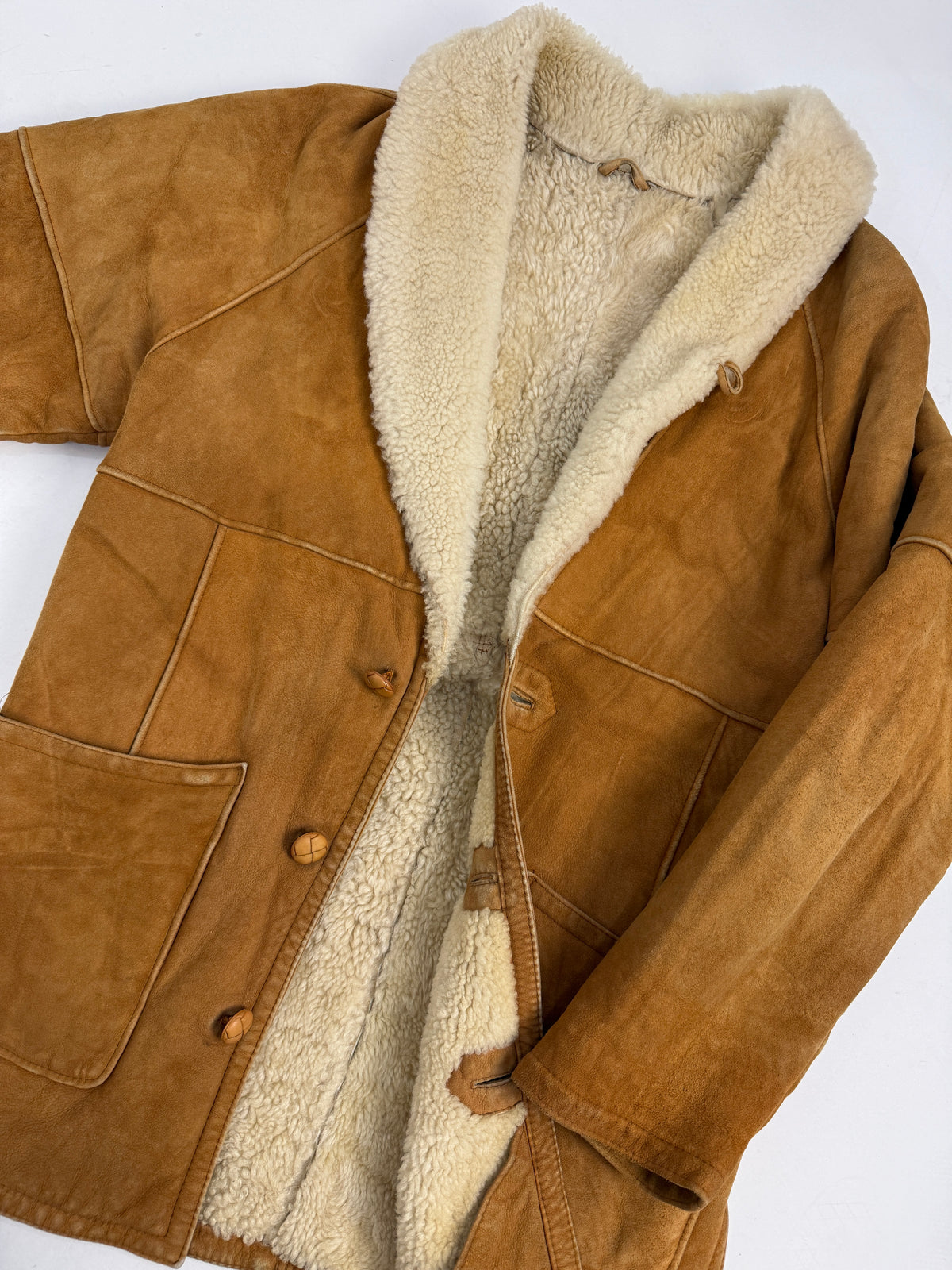 Swearling giacca montone - fronte indossato semi-aperto, quattro bottoni resina cuoio coordinati, tasche toppa frontali, yoke sprone anteriore cucitura a vista, pelo riccio colletto