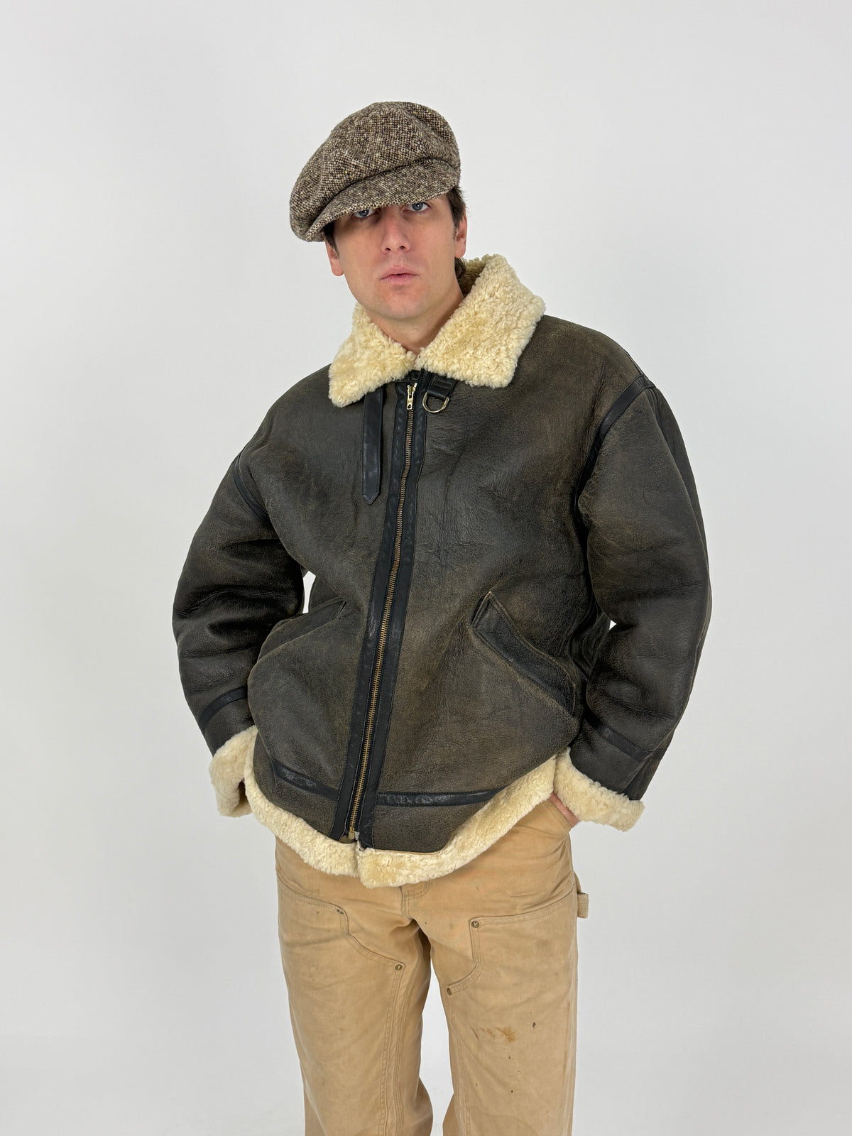 Menichelli bomber montone retro indossato - pannellatura tre pannelli verticali yoke superiore cucitura orizzontale, fascette laterali fibbia vita destra, nappa ebano patina oliva spalle cognac, shearling bordo fondo