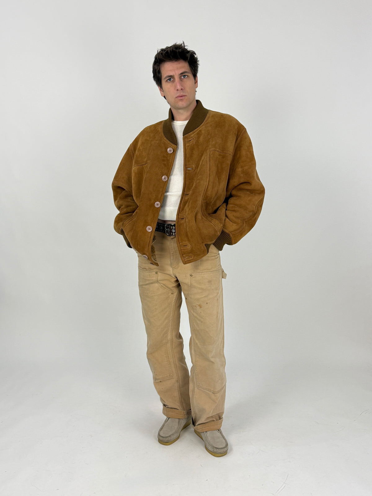Bomber suede tabacco - figura intera frontale indossato, costine oliva collo polsini fondo, 4 bottoni bianchi avorio, tasche basse taglio orizzontale, fodera teddy caramello bordo petto