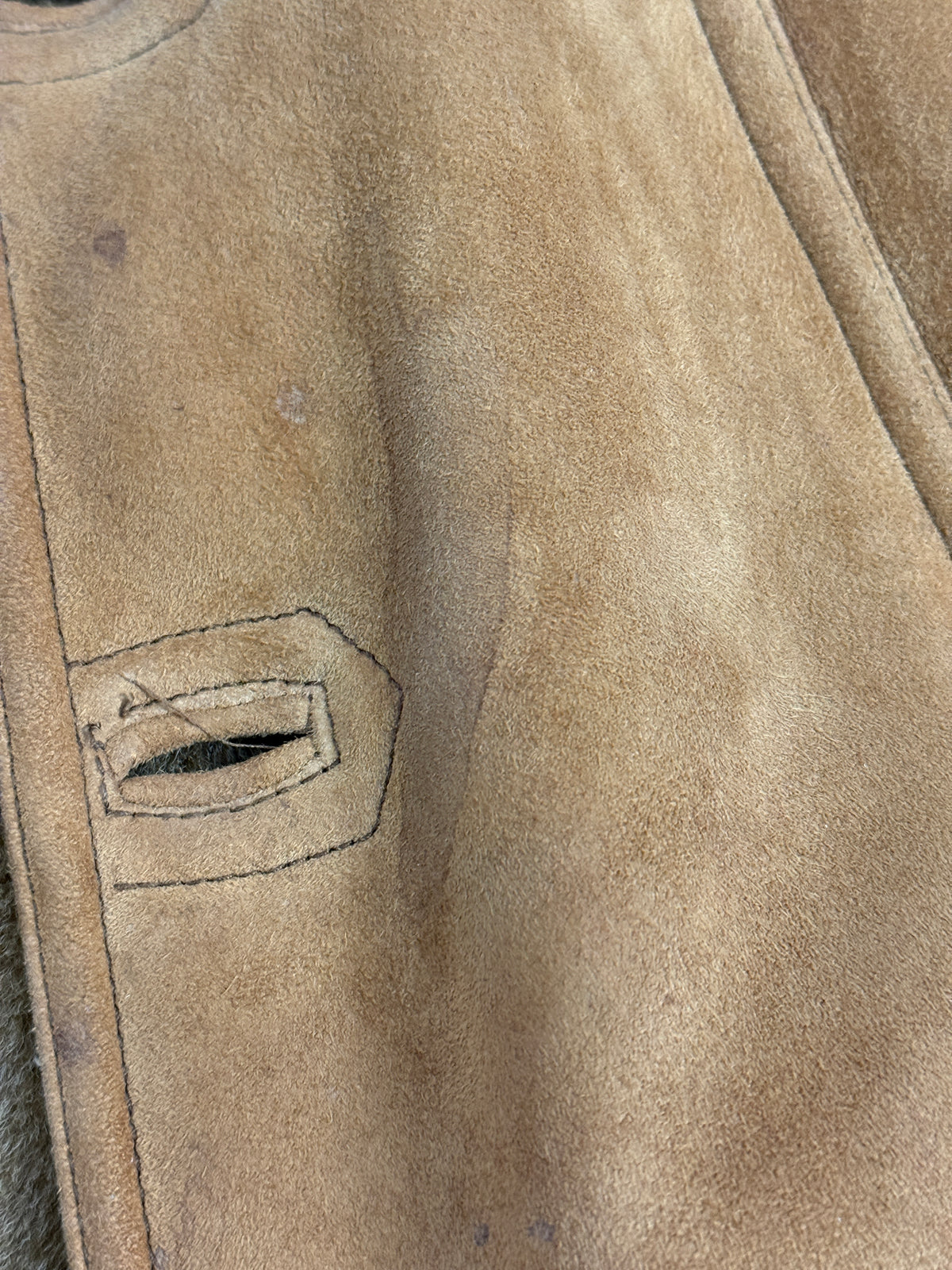 Dettaglio macro piano - suede tabacco con macchie aloni umidità dichiarate removibili con gomma camoscio, piccola tasca passamano welt bordo suede applicato cucitura vista, cuciture longitudinali manica filo coordinato
