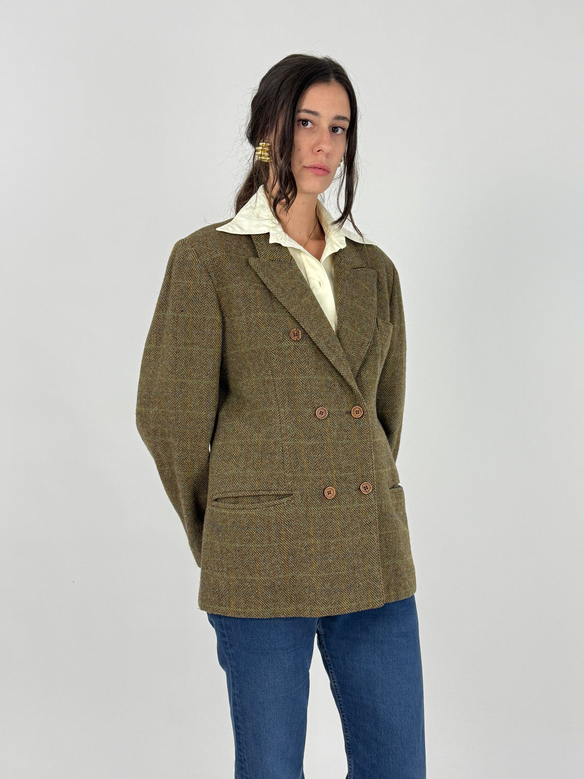 Blazer doppiopetto tweed - figura tre quarti frontale indossato aperto, revers lancia larghezza media, tweed herringbone verde oliva slubs irregolari trama, spalle cadenti fit oversize
