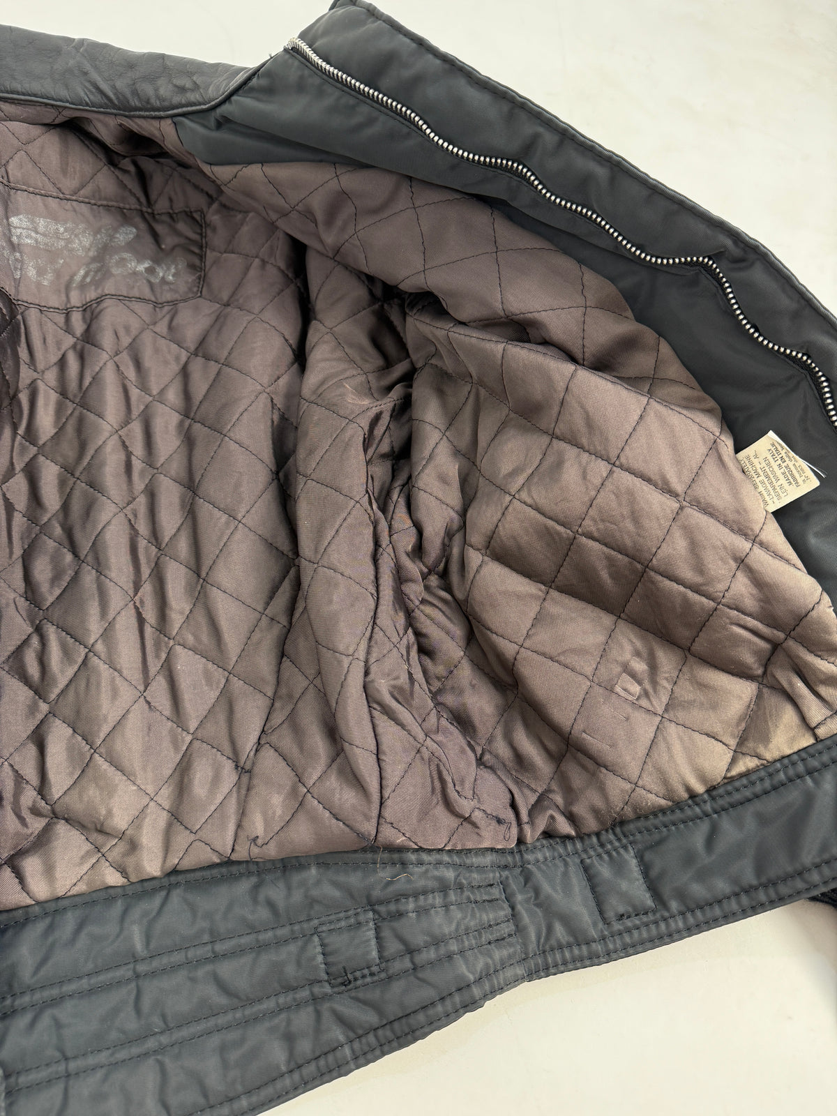 Interno aperto - fodera trapuntata a rombi grigio-lilla/mauve completa, etichetta patch Speed Mode stampata argento su fondo nero cucita interno, zip metallica argento