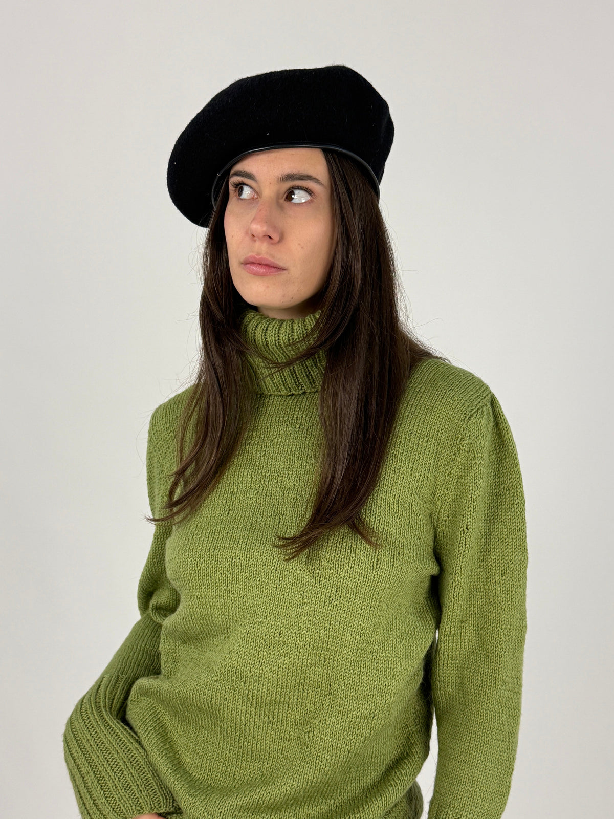Basco vintage nero indossato inclinato con dolcevita verde