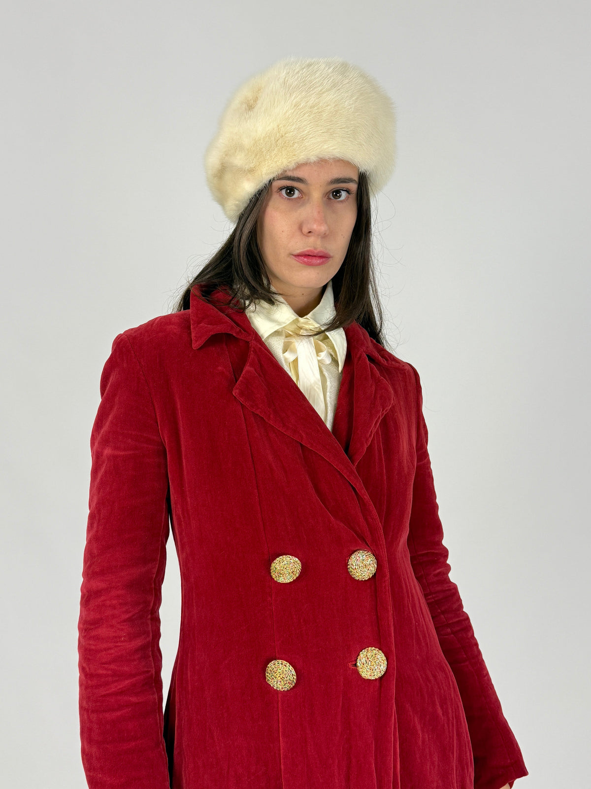 Colbacco vintage in vera pelliccia bianca indossato con cappotto rosso