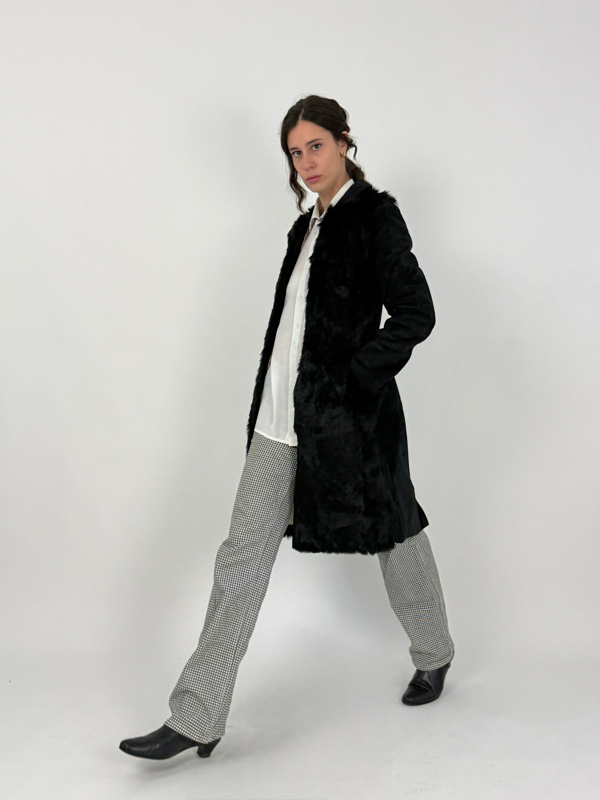 Blue Deep cappotto lapin - laterale indossato, fasce orizzontali pelli cucite visibili sul corpo, silhouette diritta lunghezza cm 97, colletto revers pelo lungo aperto