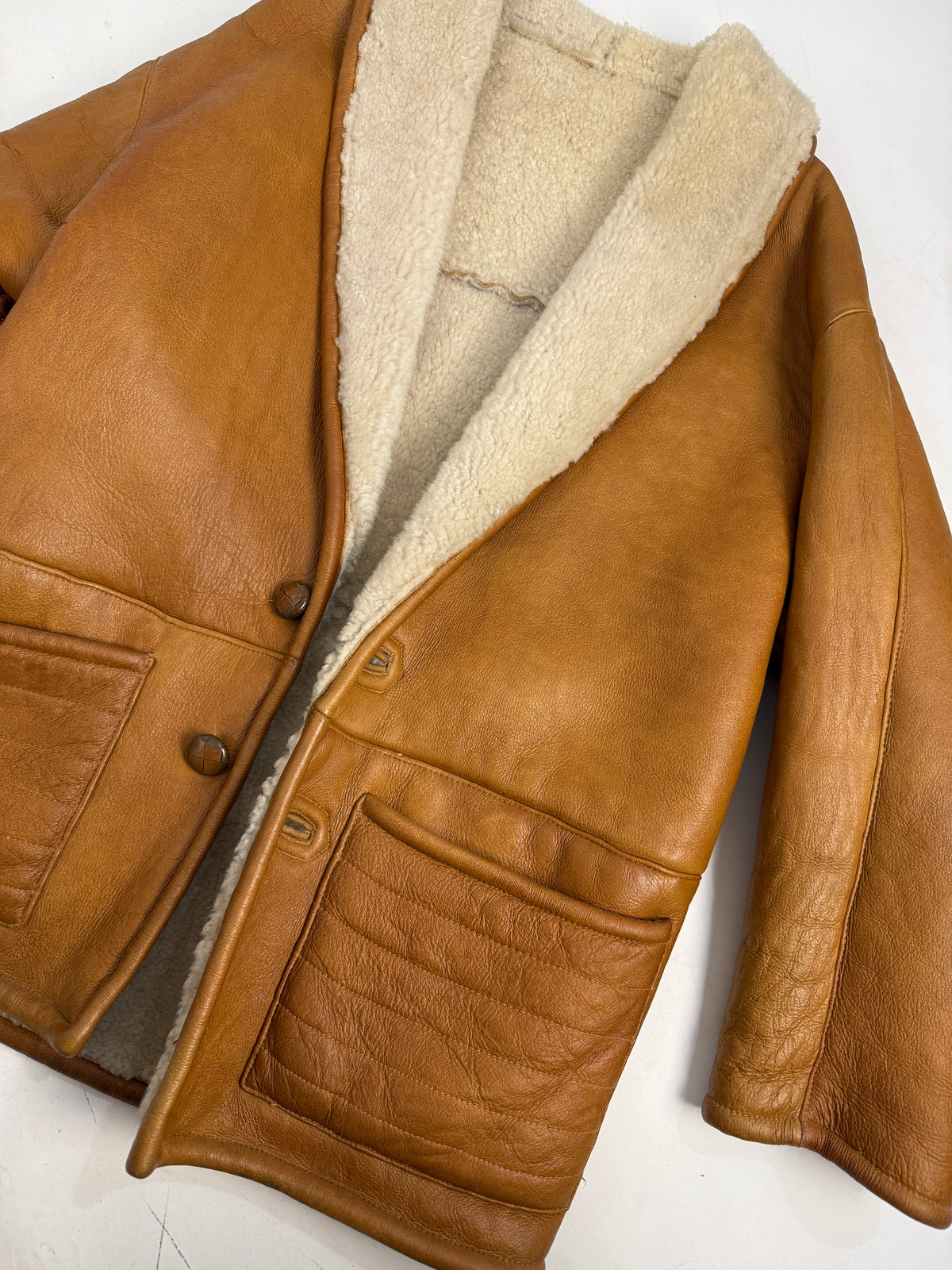 Giacca montone nappa cognac vintage anni 70 fronte indossato aperto - colletto scialle shearling riccio avorio, toggle legno naturale chiaro, tasca toppa petto, tasche soffietto basse, taglia M